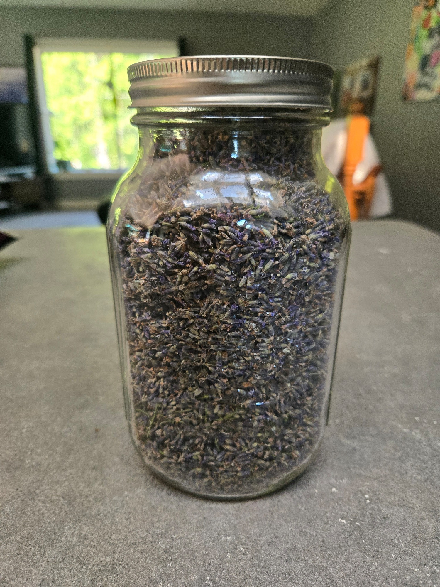 A 1.5 quart jar full of dried lavender flowers.
