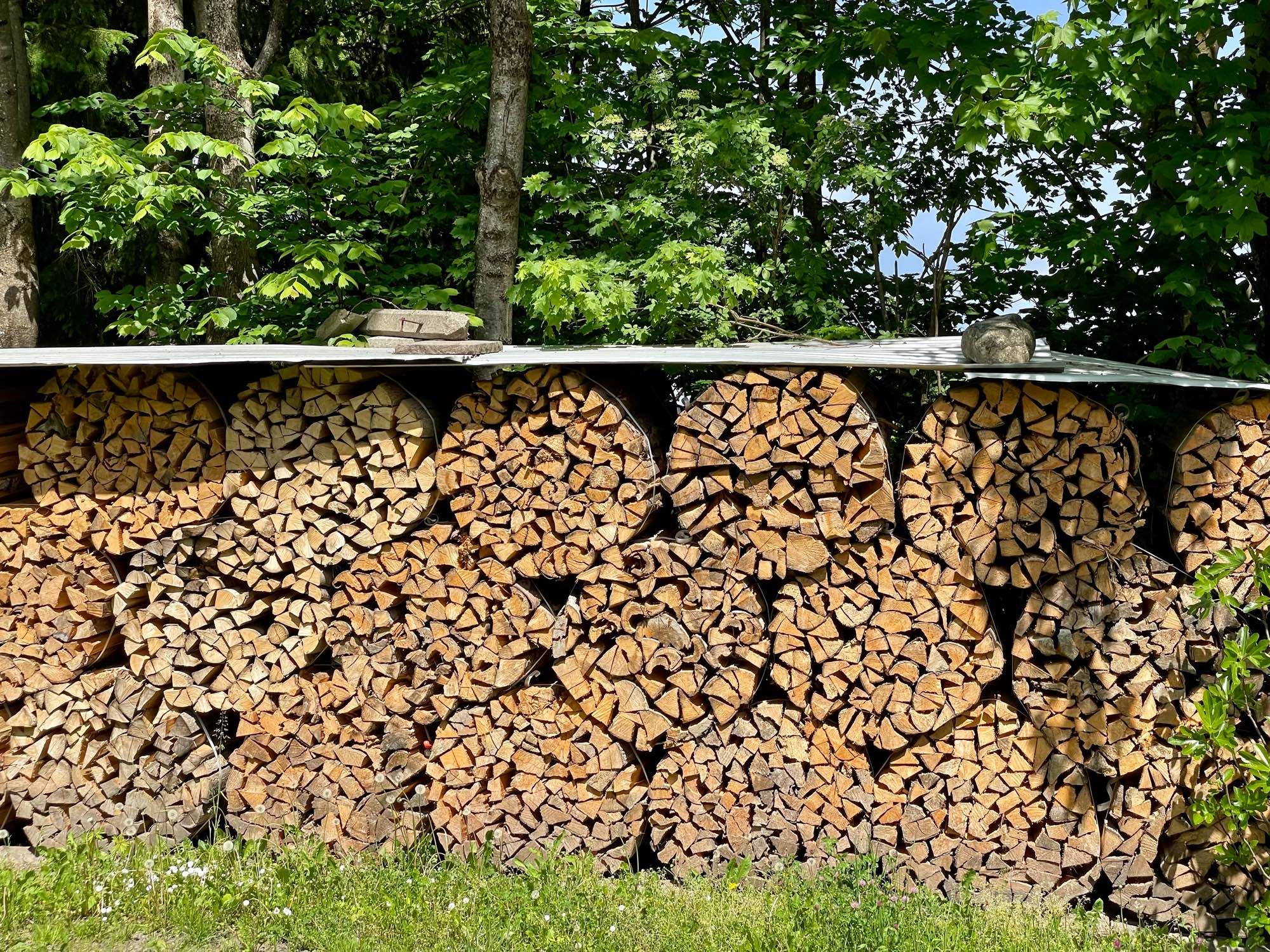 Holzstapel mit kreisrunden Holzbündeln.