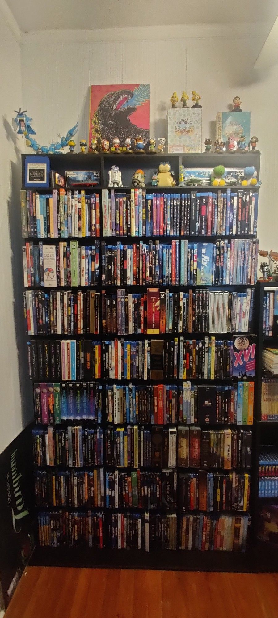 A rack of DVDs and Blu-rays. On top of that is various bric a brac