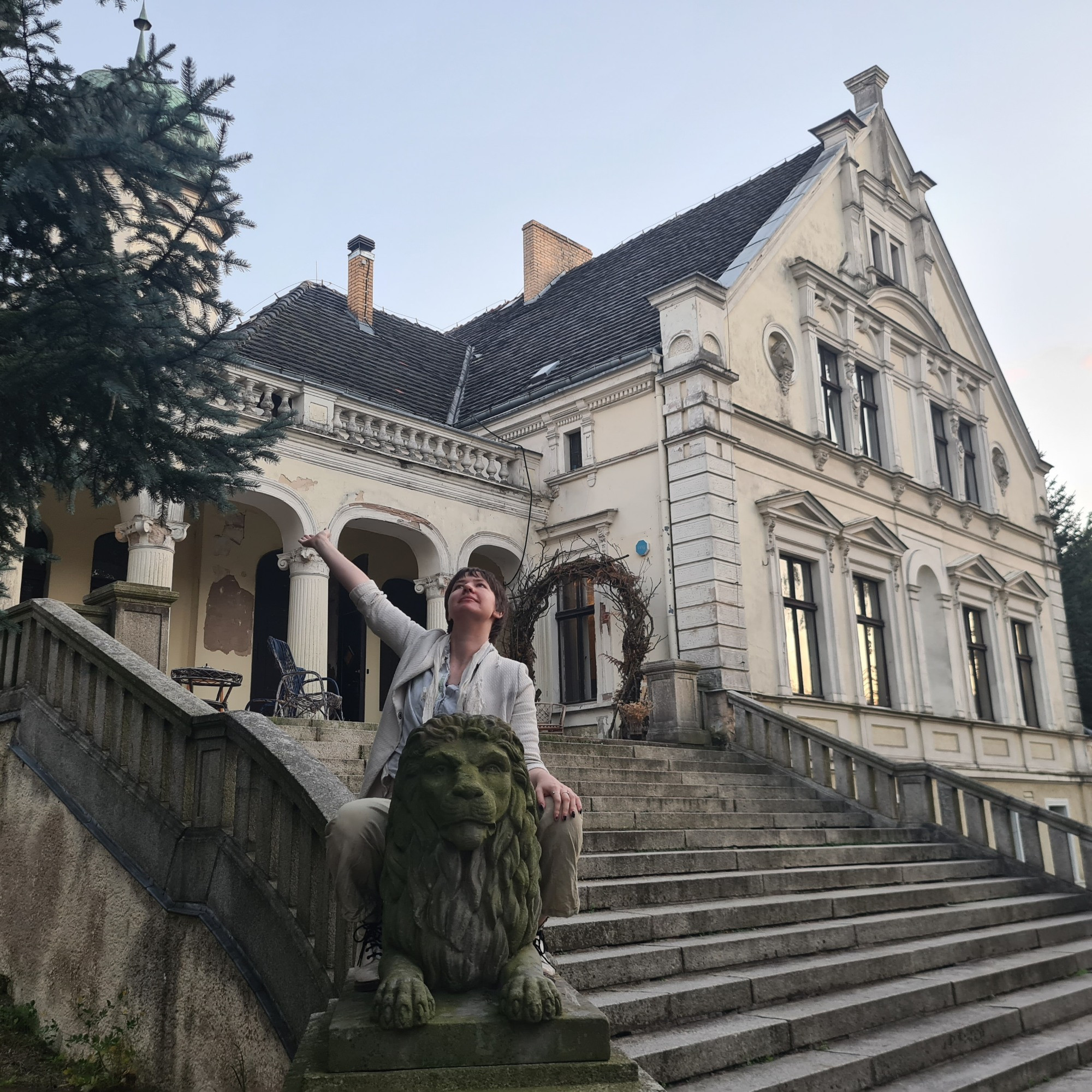 Photograph of me on a lion statue in front of a house
