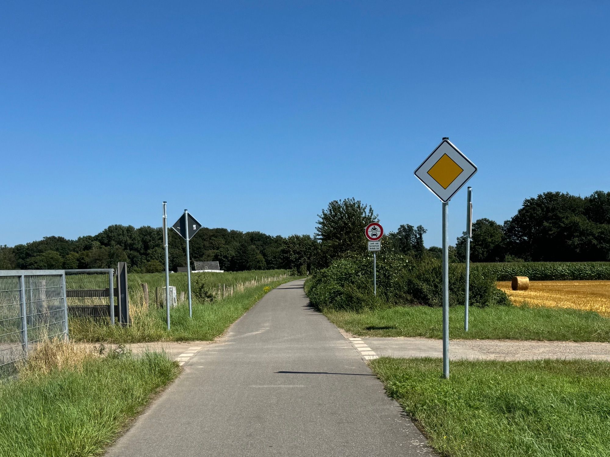 Blick von einem Fahrradweg auf einen kreuzenden Wirtschaftsweg. Der Fahrradweg hat neuerdings Vorfahrt.