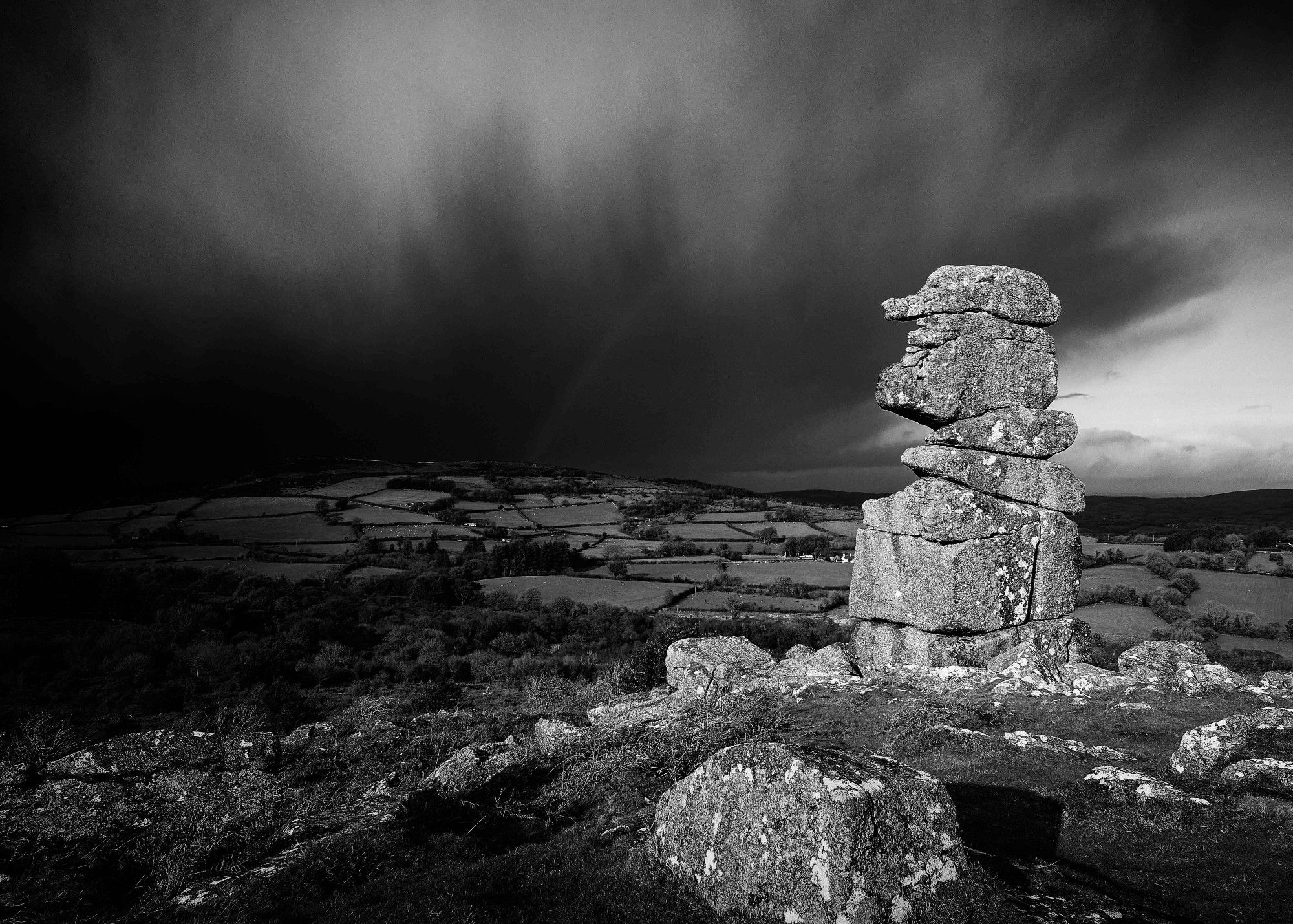 Black and White image of a Winter Storm approaching Bowerman's Nose, Dartmoor. Image Copyright Will Tudor of Thorn Valley Studios. All Rights Reserved. No use without permission.