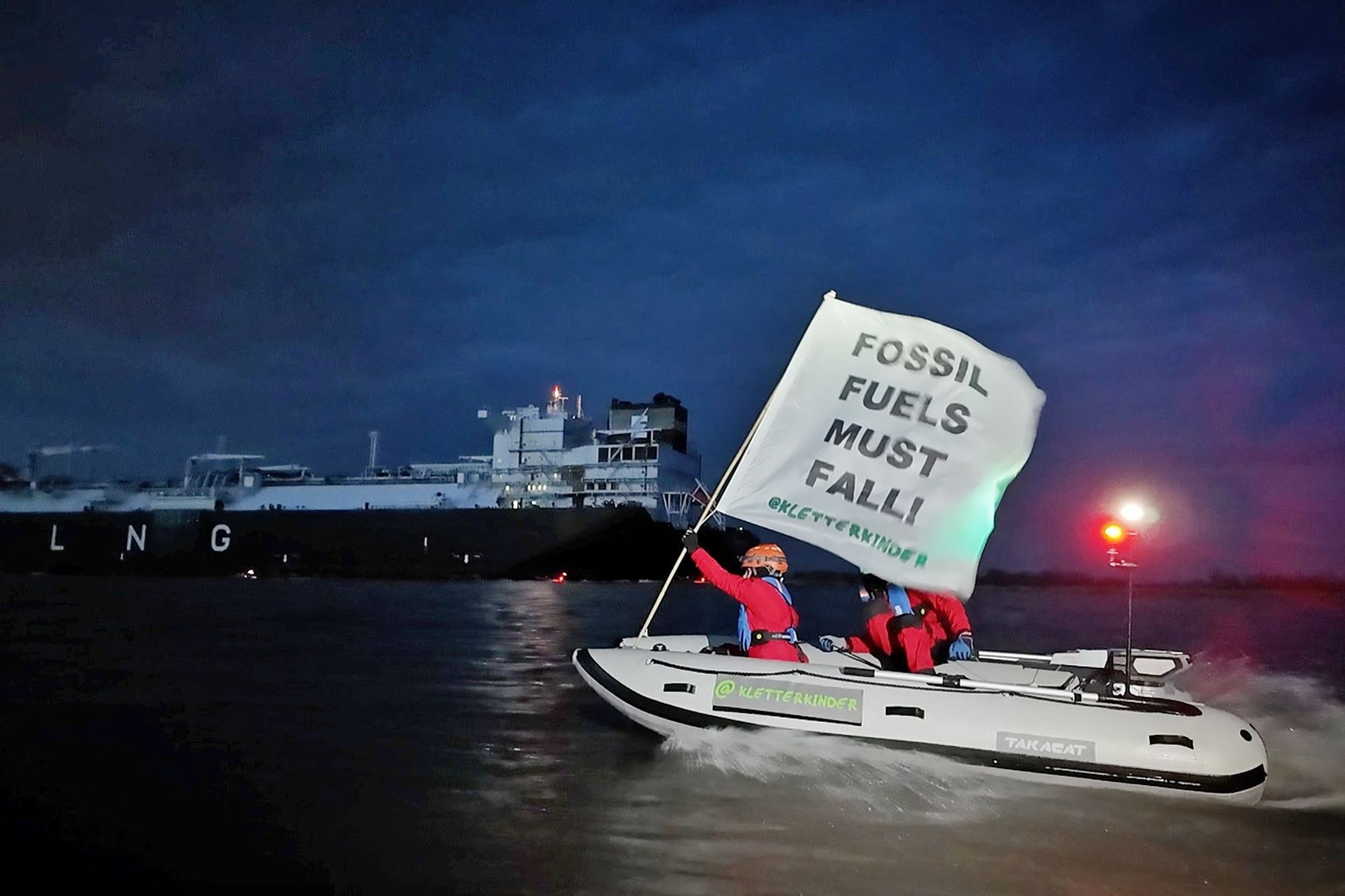 Photography of the Kletterkinder in action sailing their little E-powered inflatable catamaran on river Elbe near Stade towards a 300 m long floating LNG terminal vessel. Picture taken on March 15 during dawn. (© Kletterkinder)