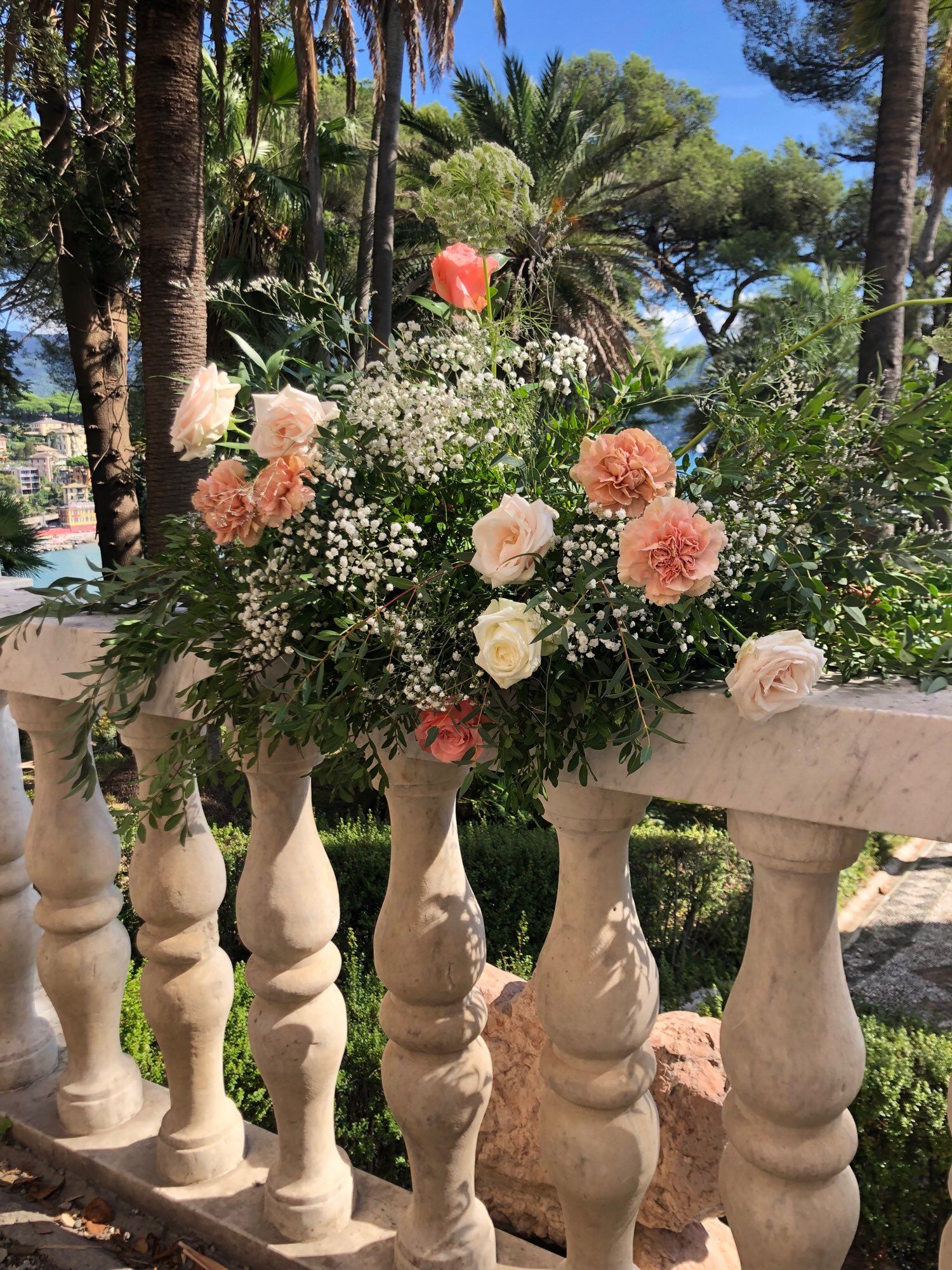 A bouquet of laurel, cow parsley, carnations—of differing hues, and baby’s breath. 
On a balustrade that is graced by Italian sunshine.