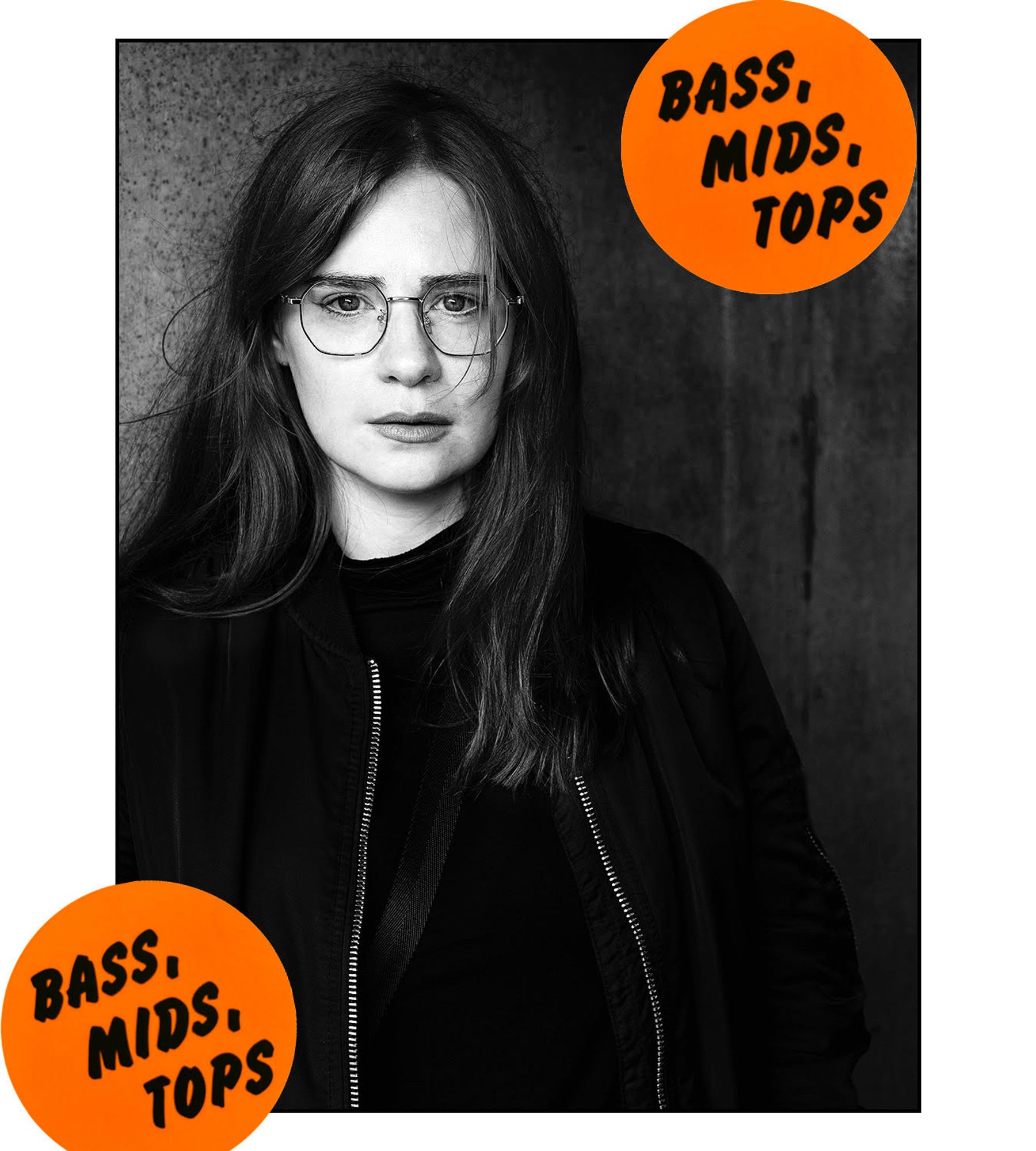 photo of Lara Rix-Martin by Brian David Stevens in black & white, wearing specs and a zipped leather jacket over black top - there are orange "BASS, MIDS, TOPS" 'stickers' on opposite corners of the picture