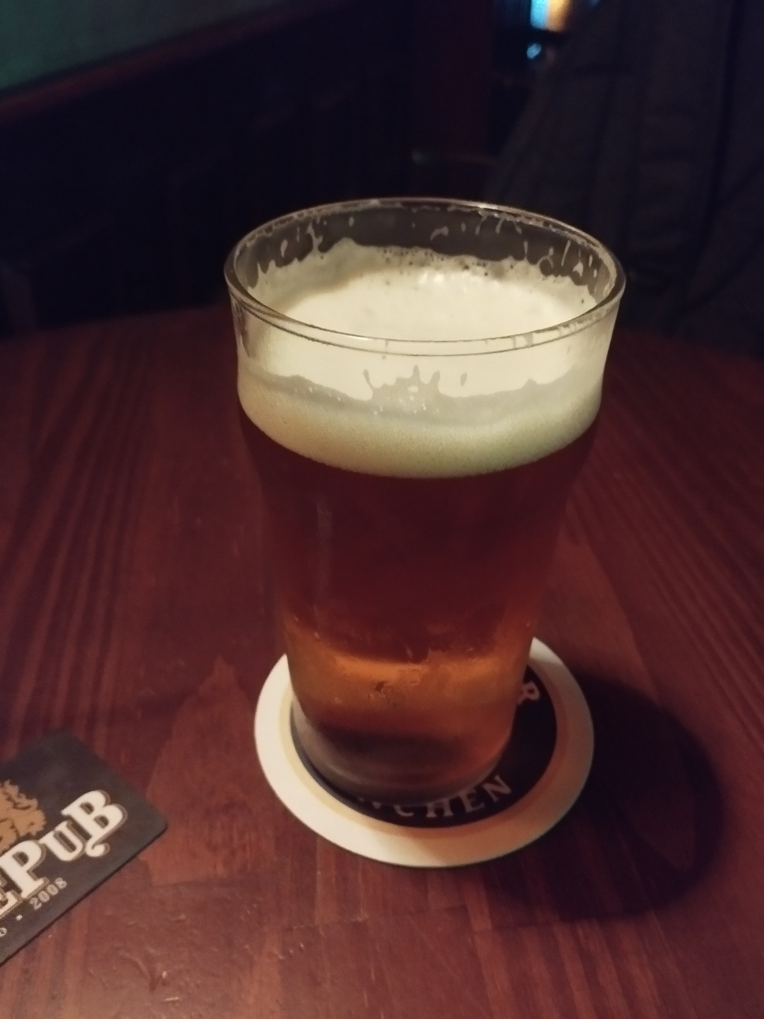 Pint com cerveja IPA Brooklyn numa mesa de madeira