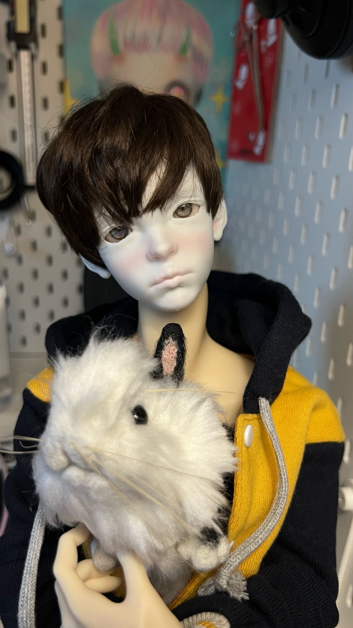 Ball jointed doll with a bunny in their jacket.