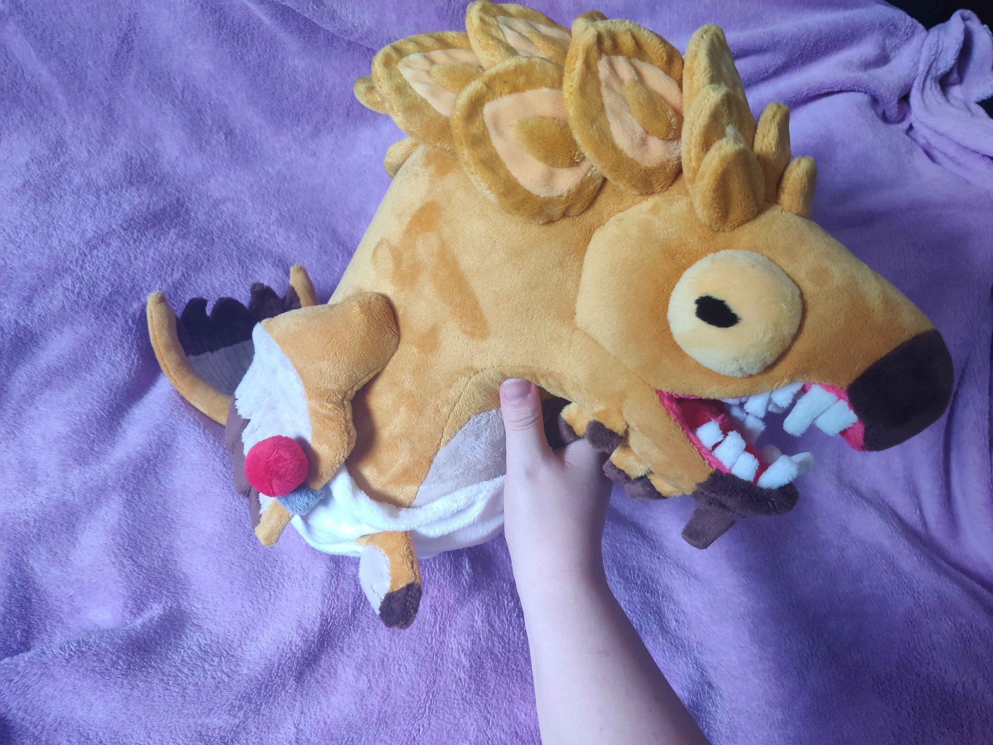 A golden fish plush shown from the side