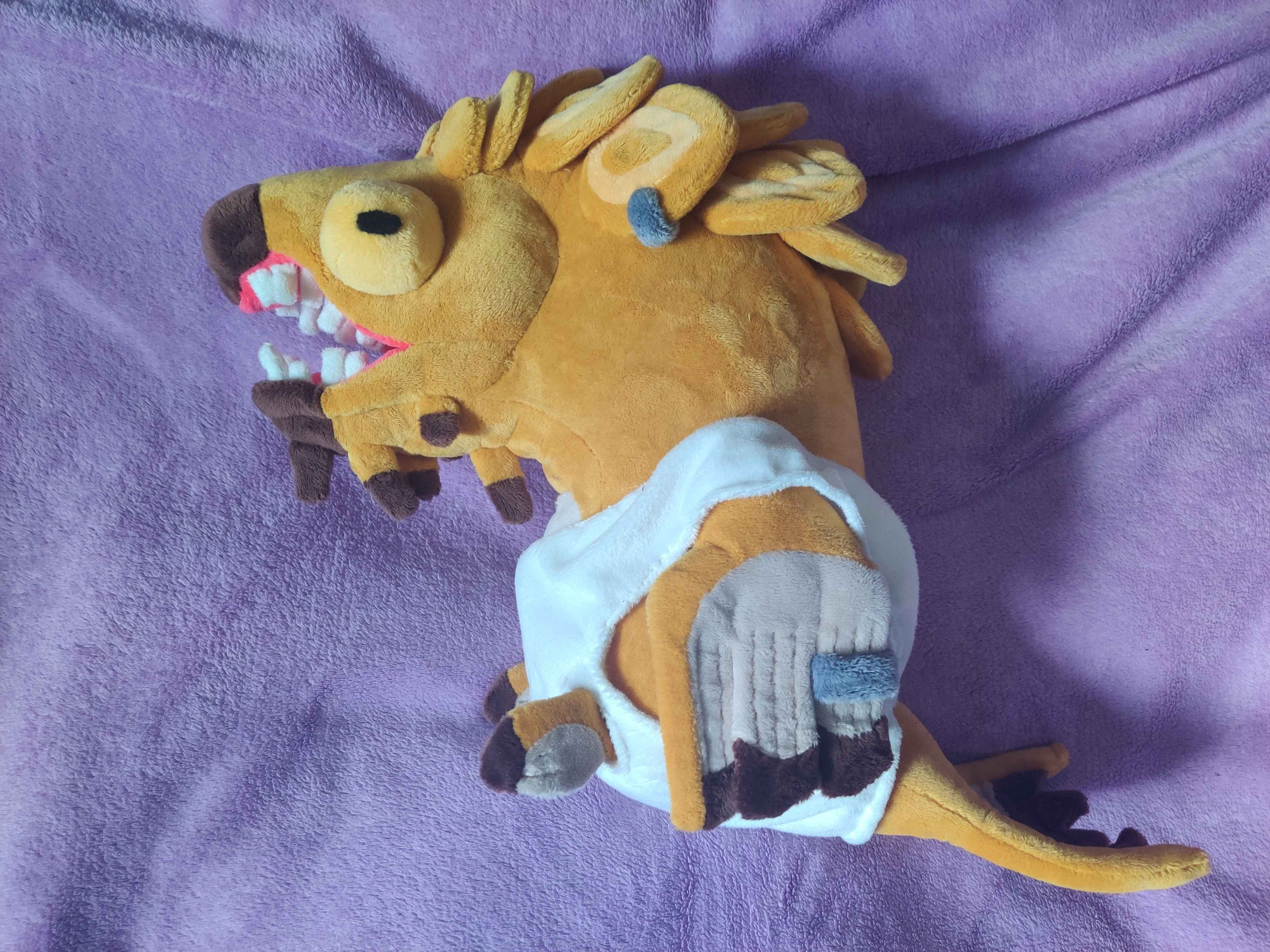 A golden fish plush shown from the left