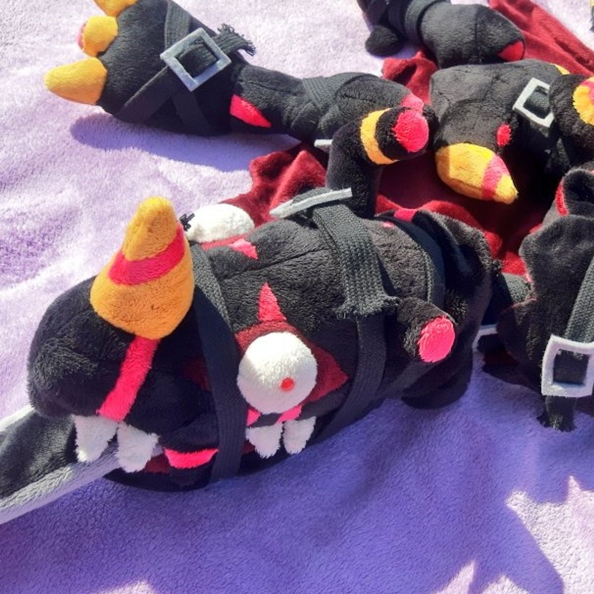 A closeup of one of the arms of the plush omegamon zwart defeat. It's a head with bulging eyes.