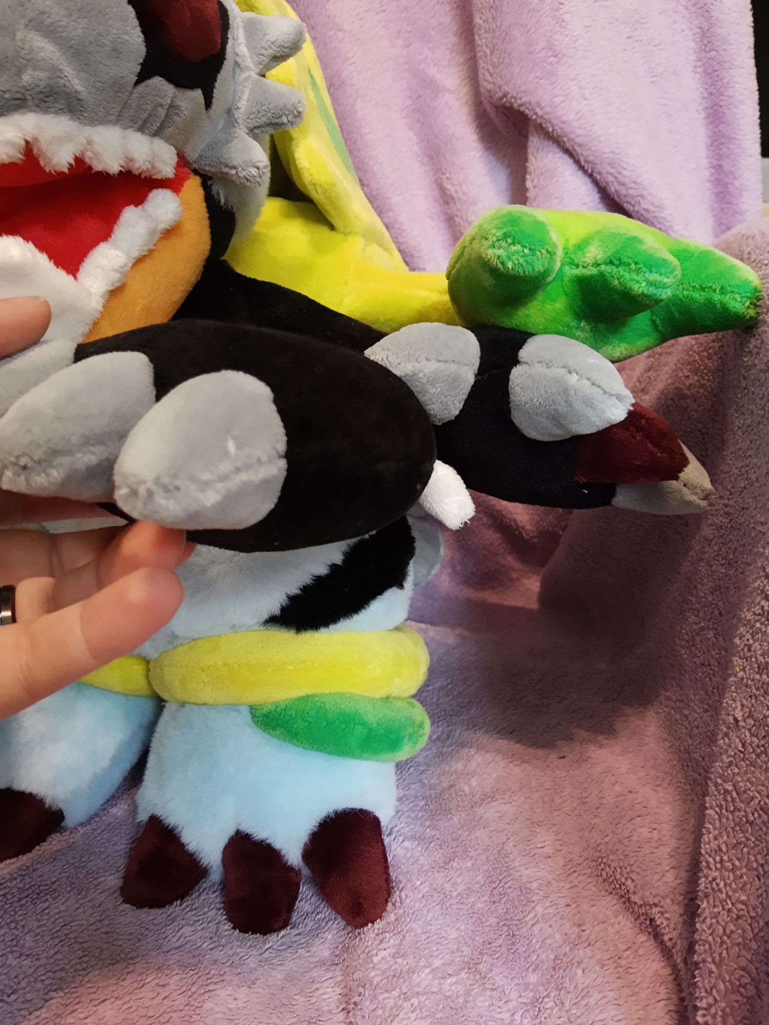 A plushie of the digimon Millenniummon. One of the arms is held up to show the legs.