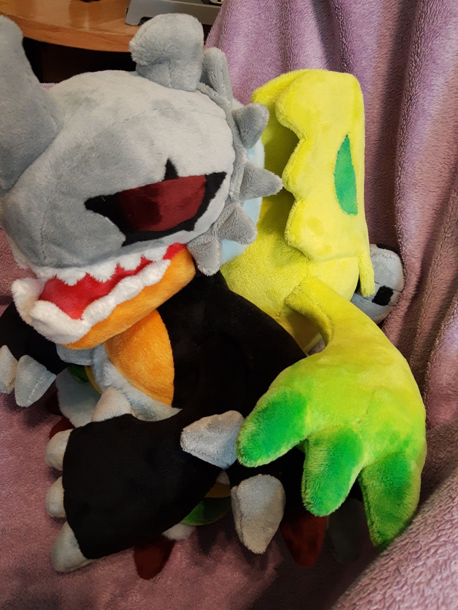 A plushie of the digimon Millenniummon. It's shown from the side to reveal the "ghost" riding its back.