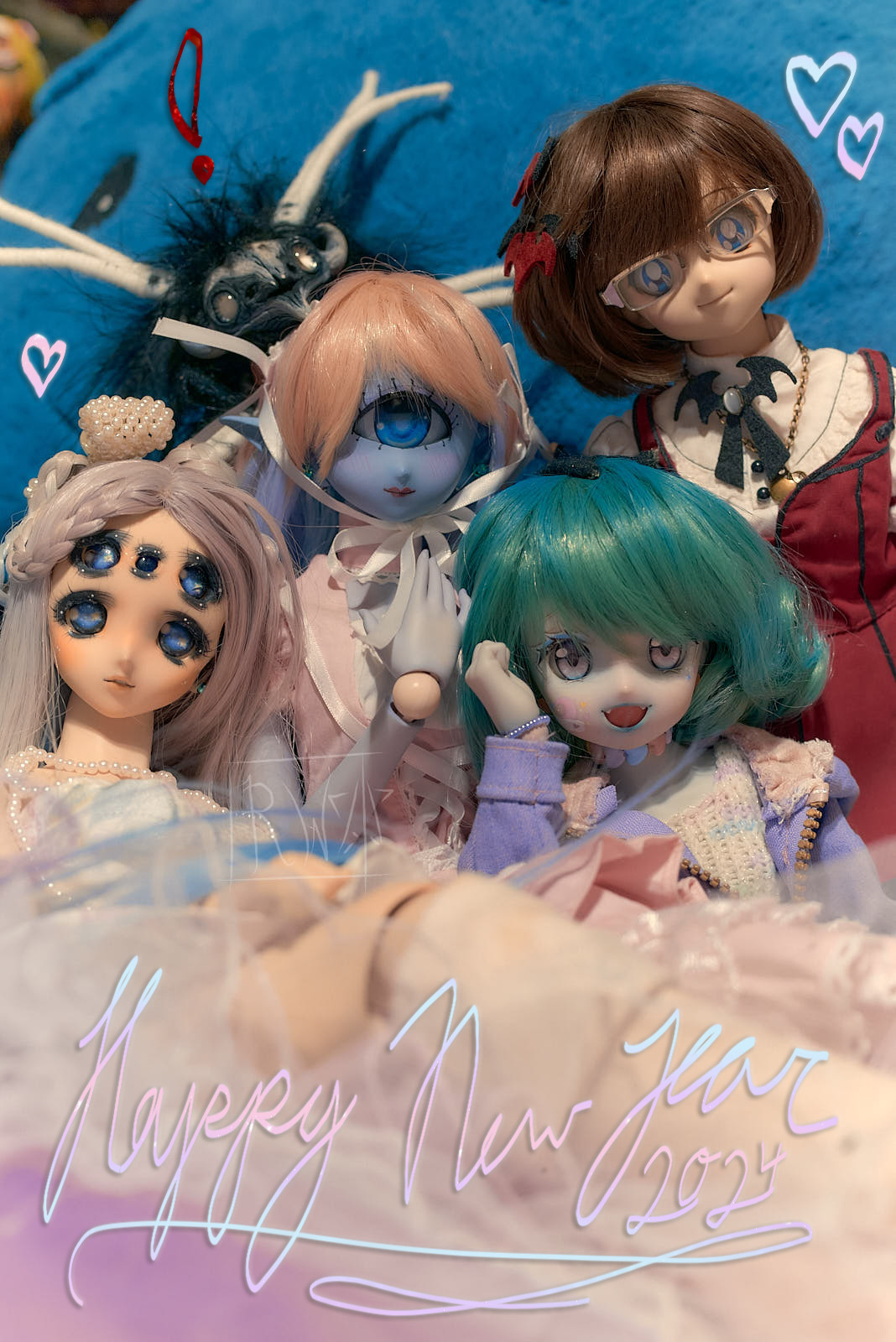 Four ball-jointed dolls are posed together. A scary-looking artdoll is posed behind them as though photobombing the image. The leftmost doll has many eyes. The one in the middle is blue, and has only one eye. Next to her, and to the bottom-right, is another blue doll with teal hair. And on the far right there is a doll with brown hair in a vaguely gothic red jumper-dress. There is text at the bottom which reads "Happy New Year 2024" in cursive handwriting, and several doodled hearts in the margins. There is also an exclamation point drawn over the head of the artdoll in the background.