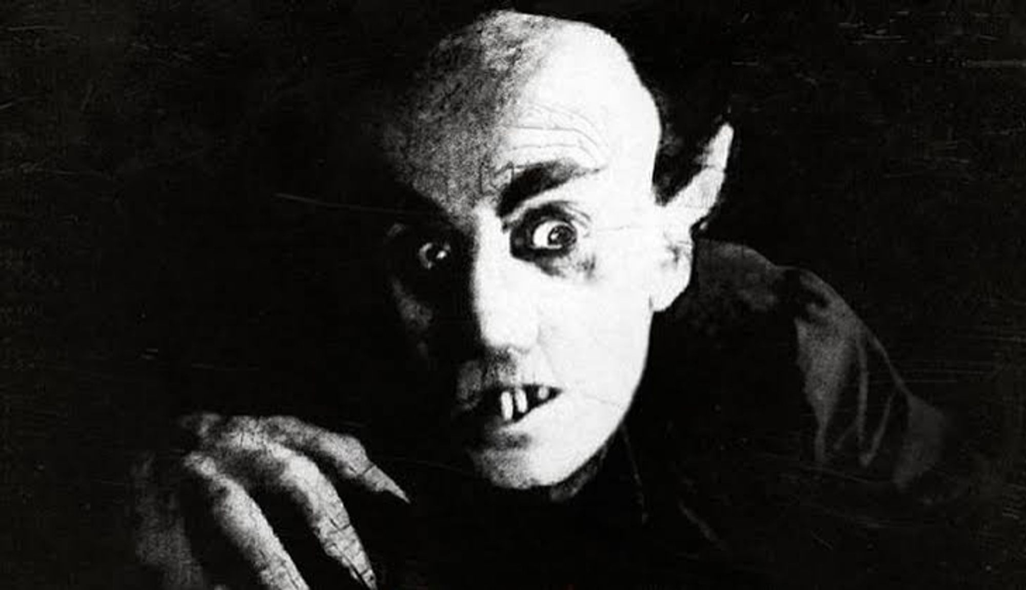 Nosferatu com seus dentinhos do meio destacados (muito distinto dos vampiros modernos com caninos grandes)