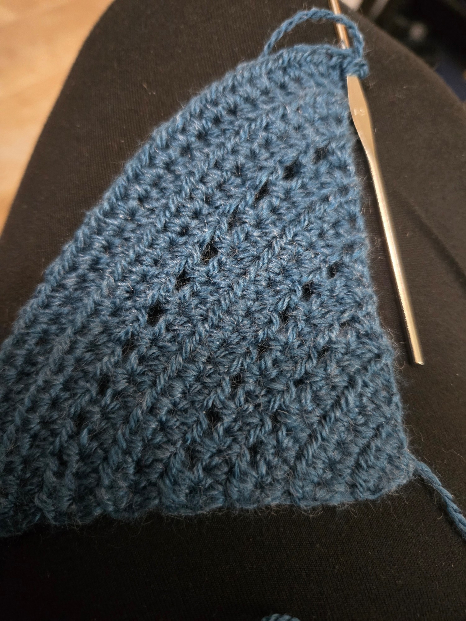 Steel blue yarn crocheted into a triangle.