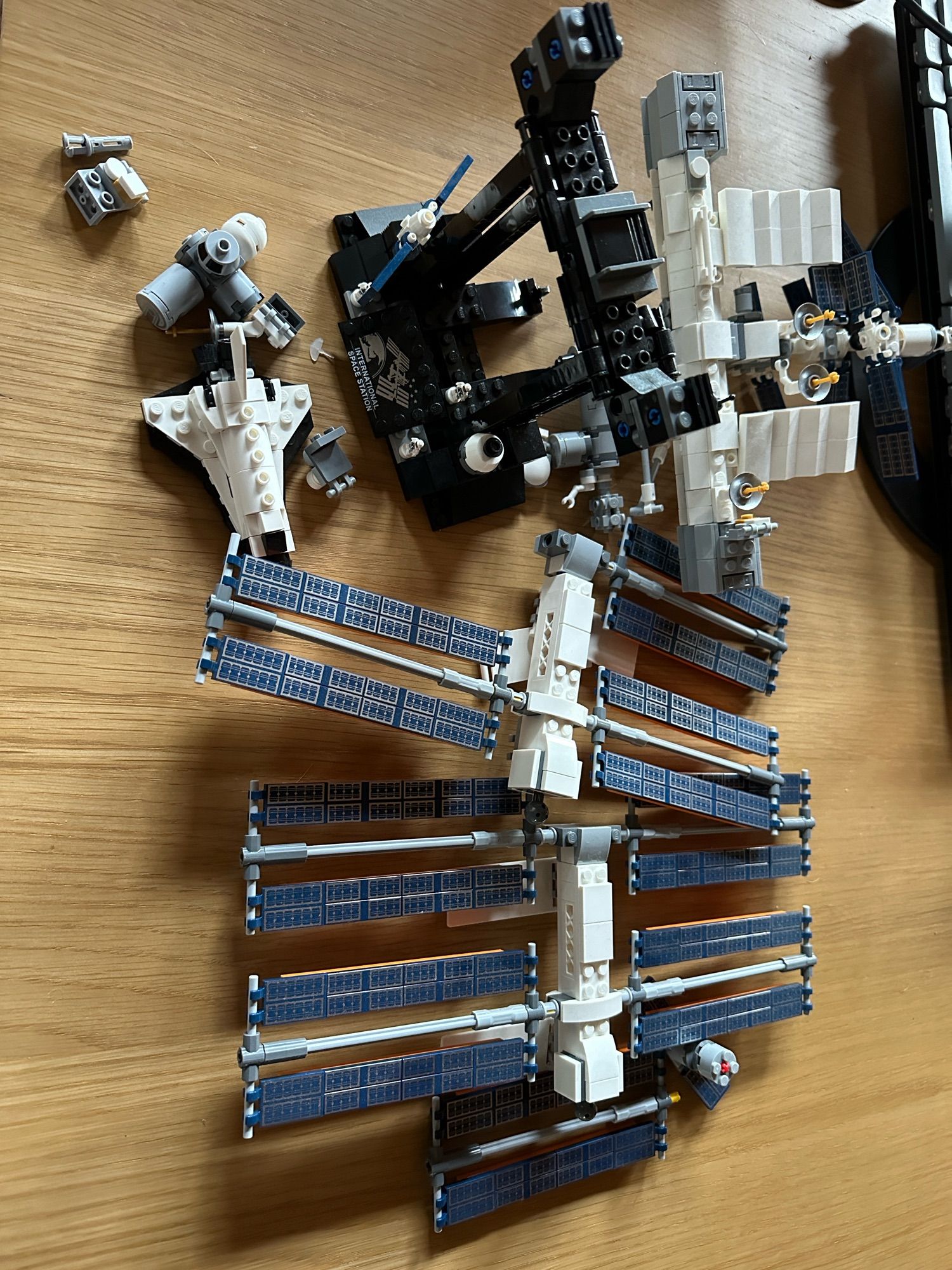 A Lego International Space Station which has fallen to the ground and is in several pieces.