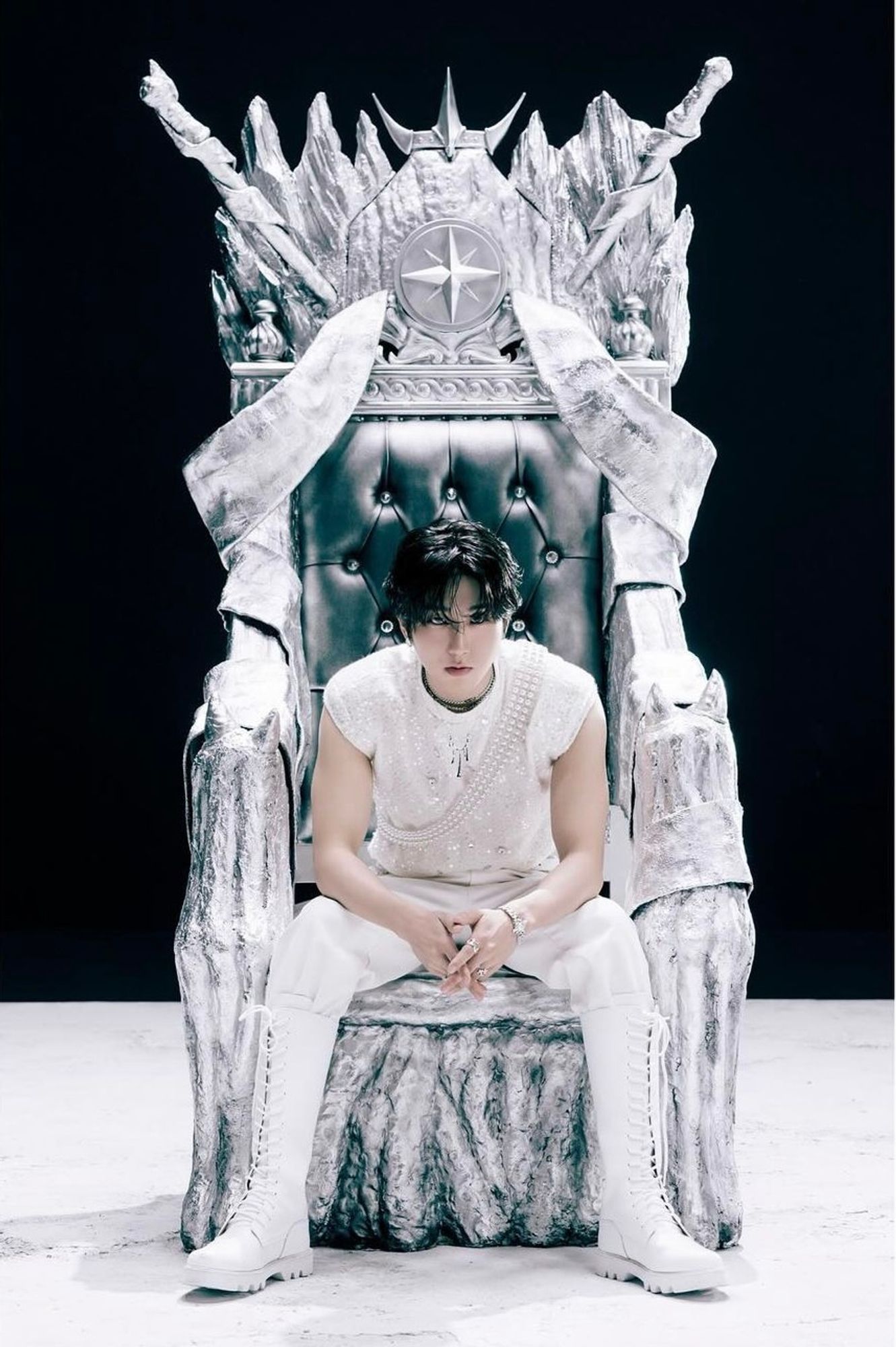 Stray Kids member HAN in an all white outfit sitting on a white and silver throne.