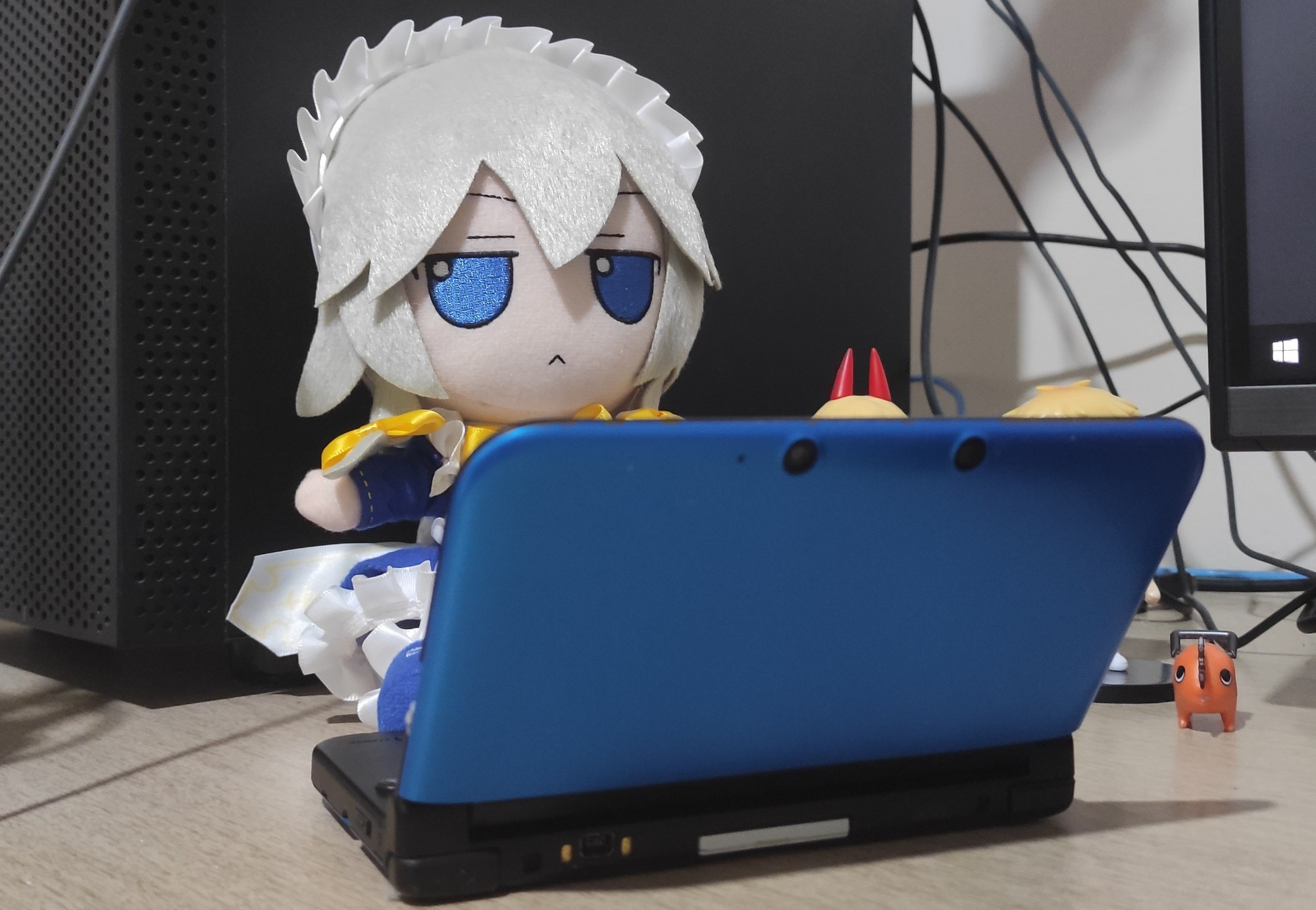 A plushie version of Sakuya Izayoi from Touhou project sitting in front of a 3DS XL mimicking a person using a laptop