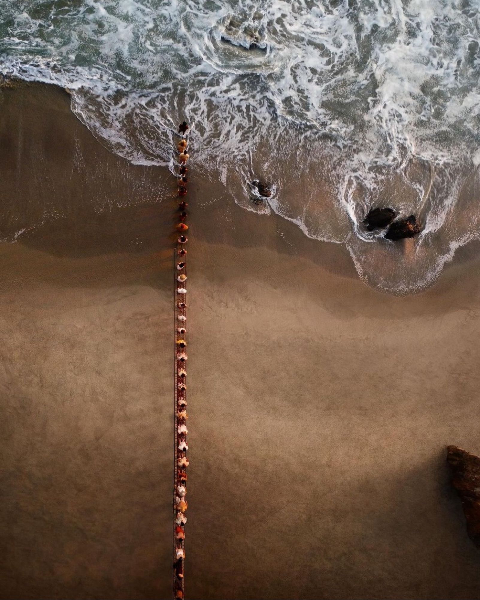 People “walking towards Gaza” on a long rug on the beach.