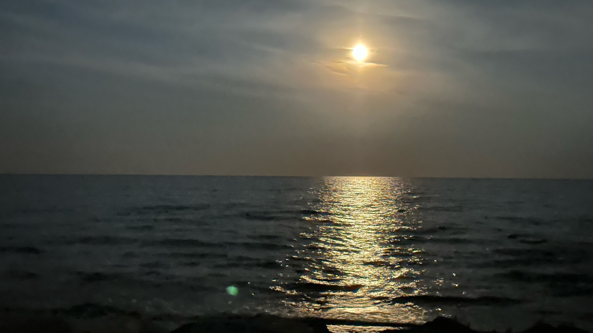 Super moon rising over Lake Michigan shoreline.