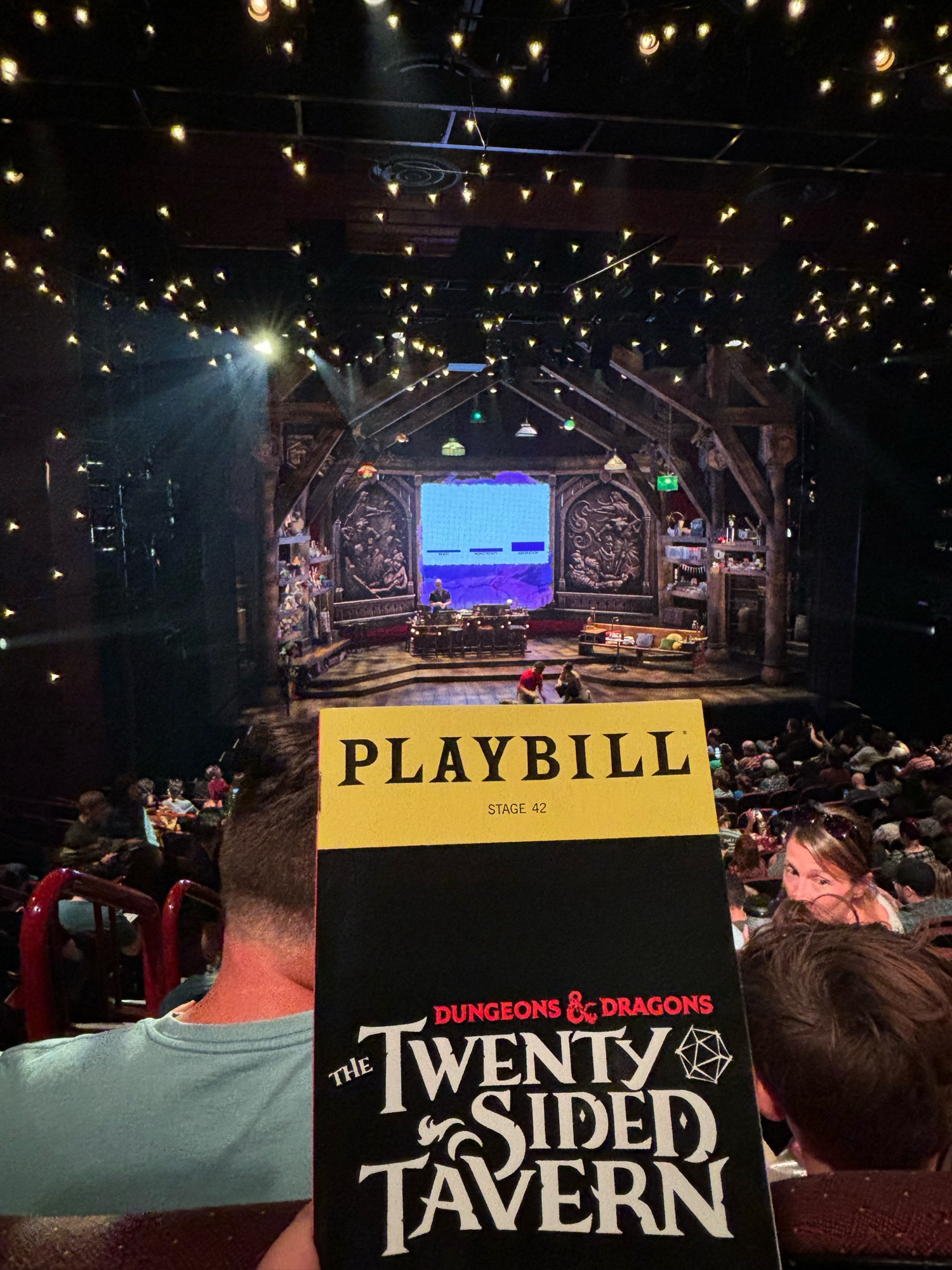 Photo of a playbill for Twenty Sided Tavern in front of the stage