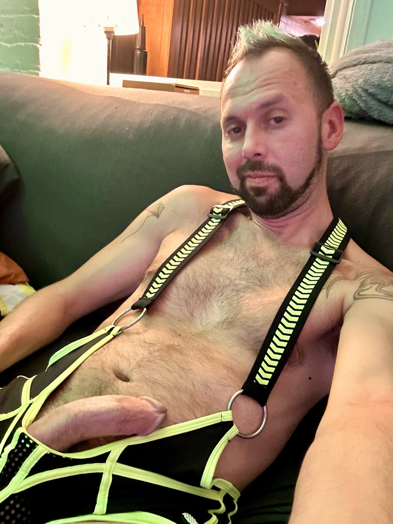 Me on a couch wearing a singlet with my hard cock sticking out