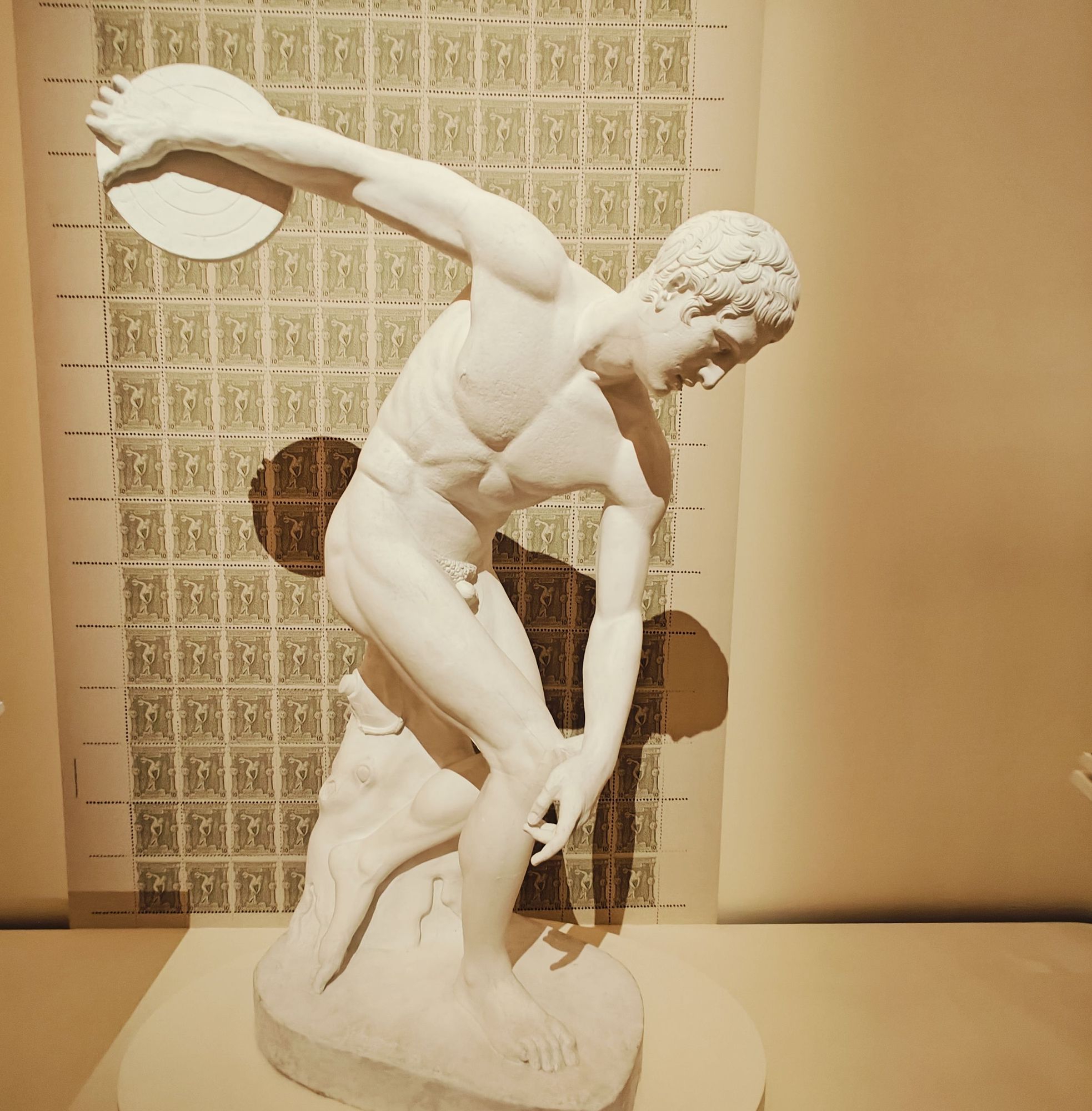 a discus thrower statue on display at the Louvre museum