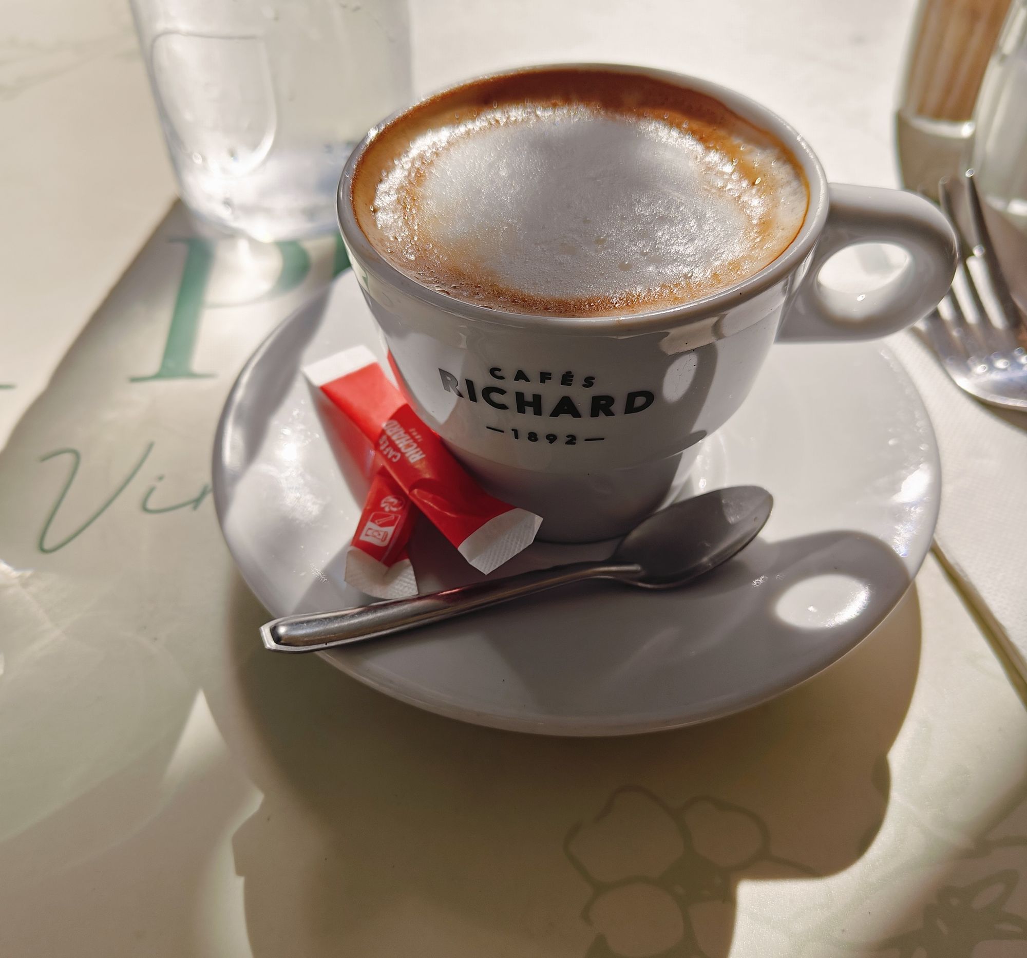 a cappuccino on an outdoor table in the morning light