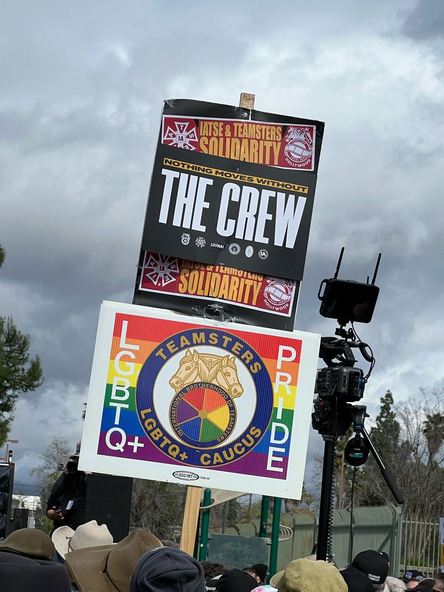 A sign promoting “Nothing Moves Without The Crew” and a Teamsters LBGTQ+ Caucus sign