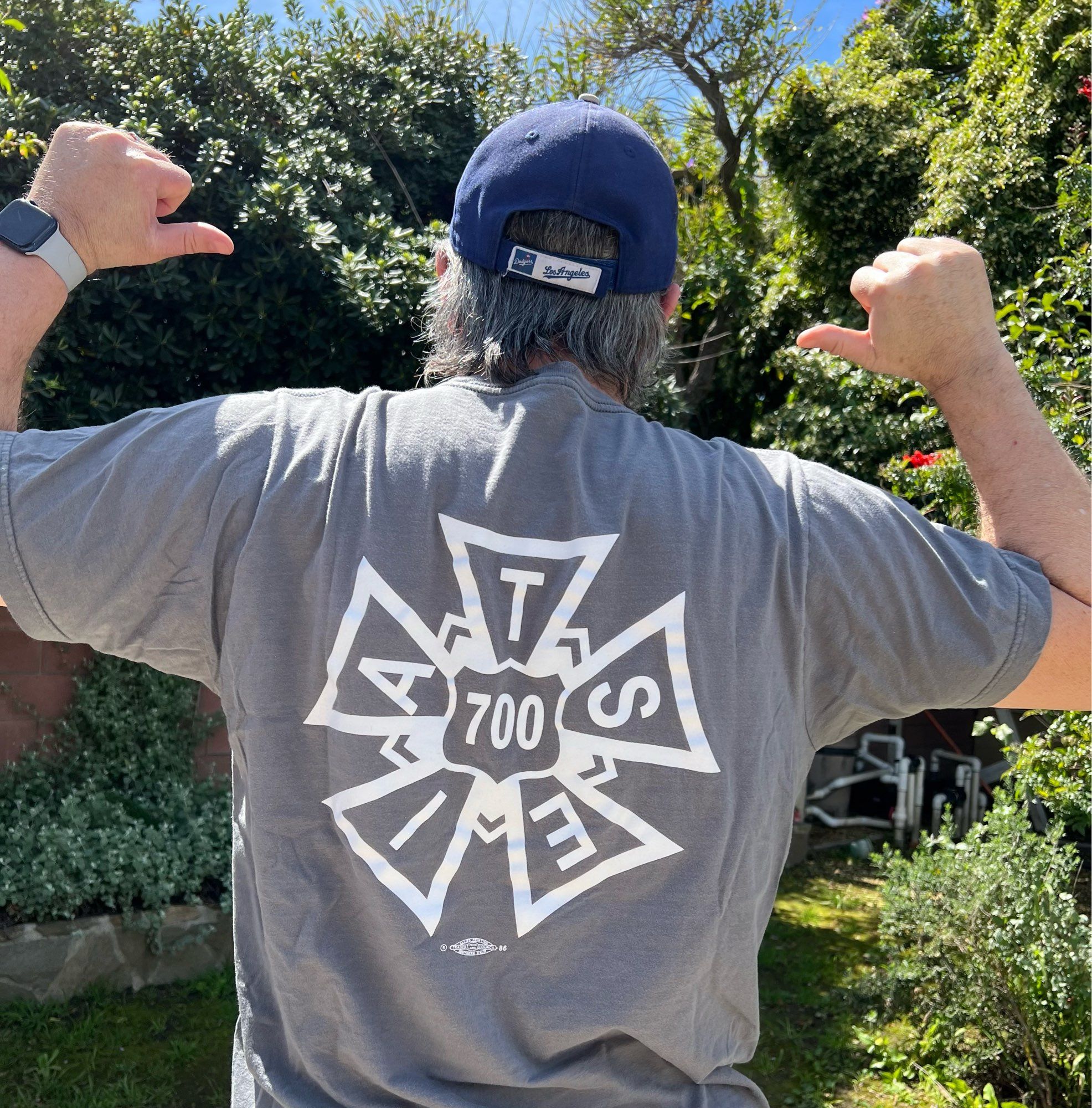 Me facing away from the camera, pointing at the back of my shirt, which shows the IATSE Local 700 logo.