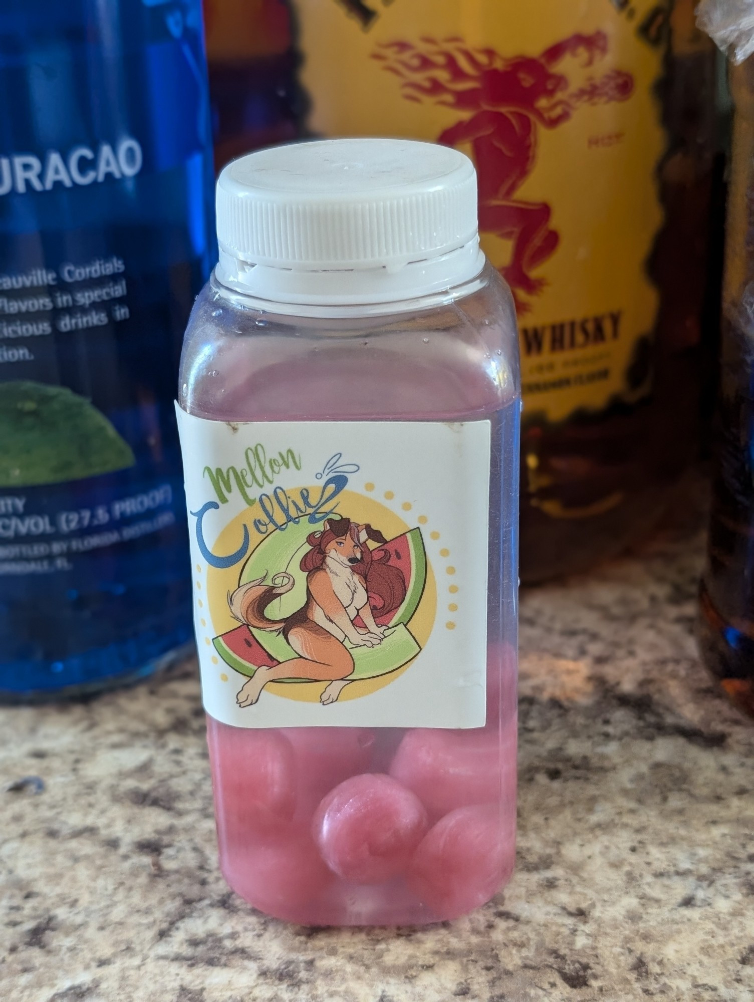 Pinkish purple hard candies in a reused plastic bottle full of clear alcohol