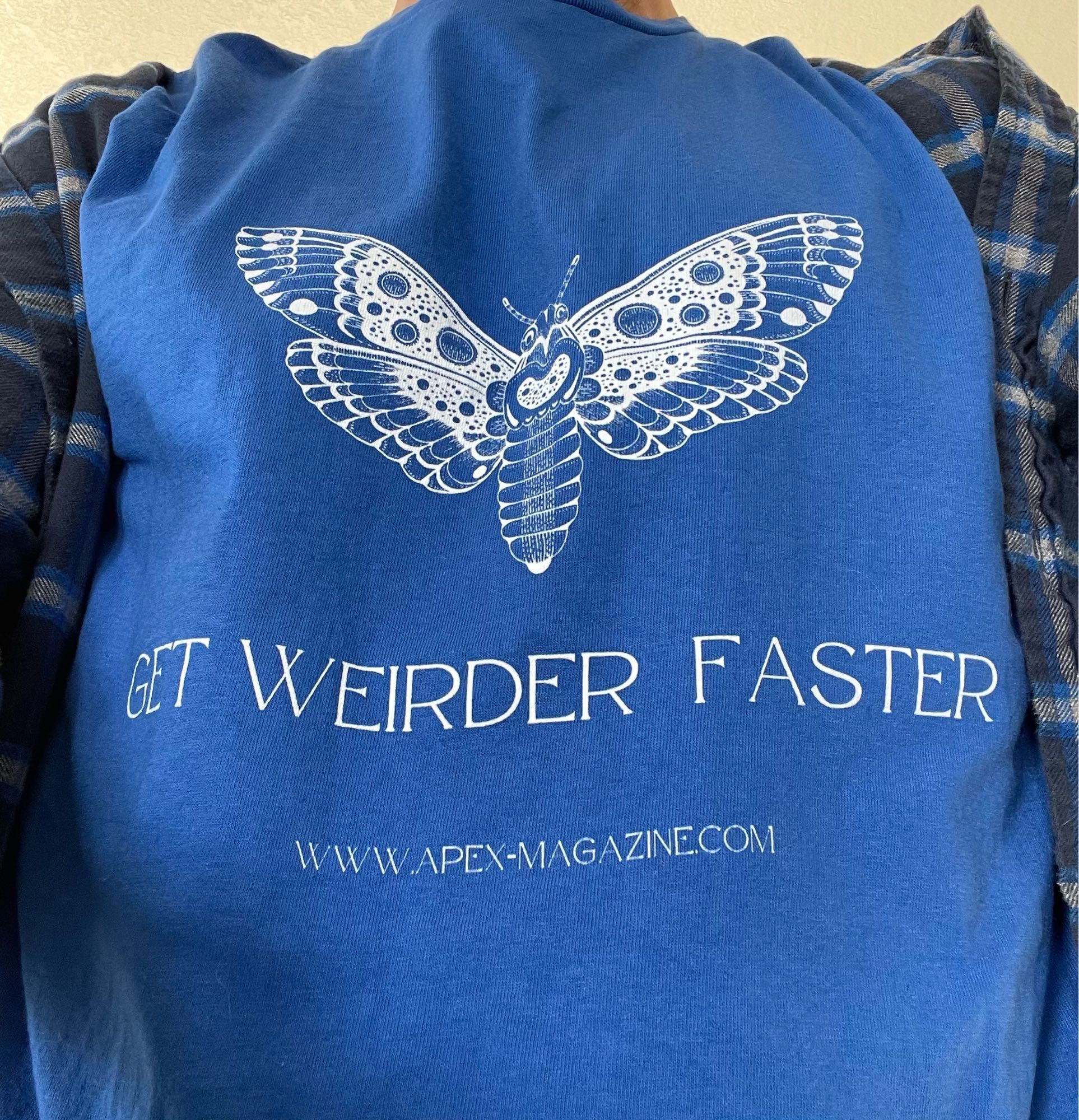 Blue t-shirt with white moth line drawing and tag line GET WEIRDER FASTER www.apex-magazine.com