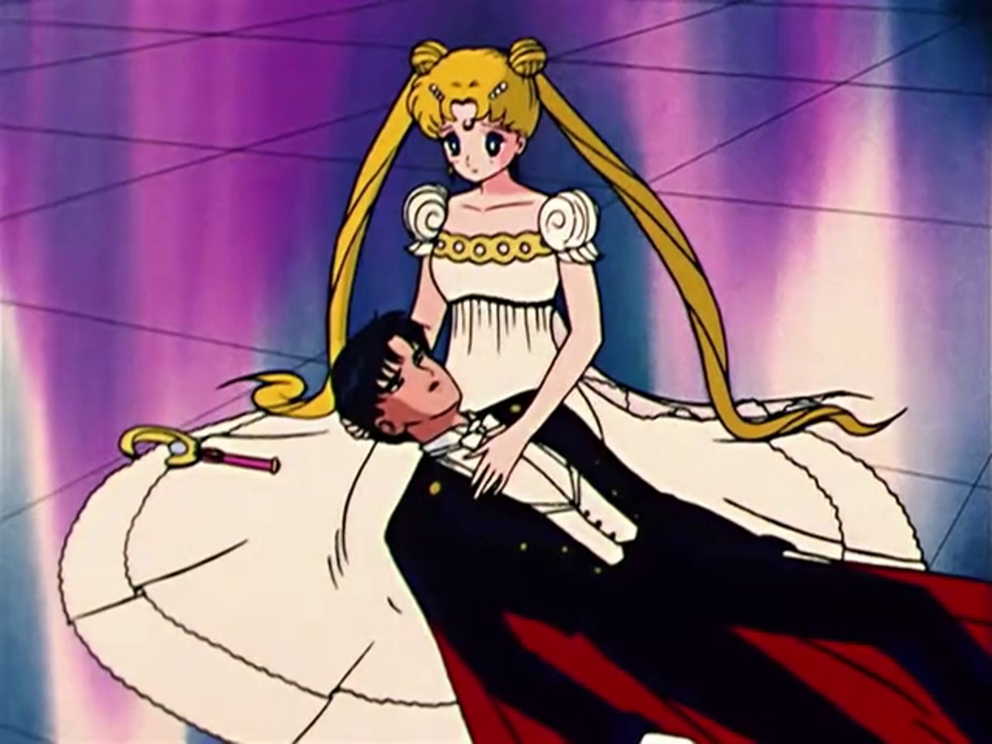 Usagi is the Moon Princess, dressed in a white ball gown with gold trim. Laying across her lap is Mamoru, dressed as Tuxedo Mask.