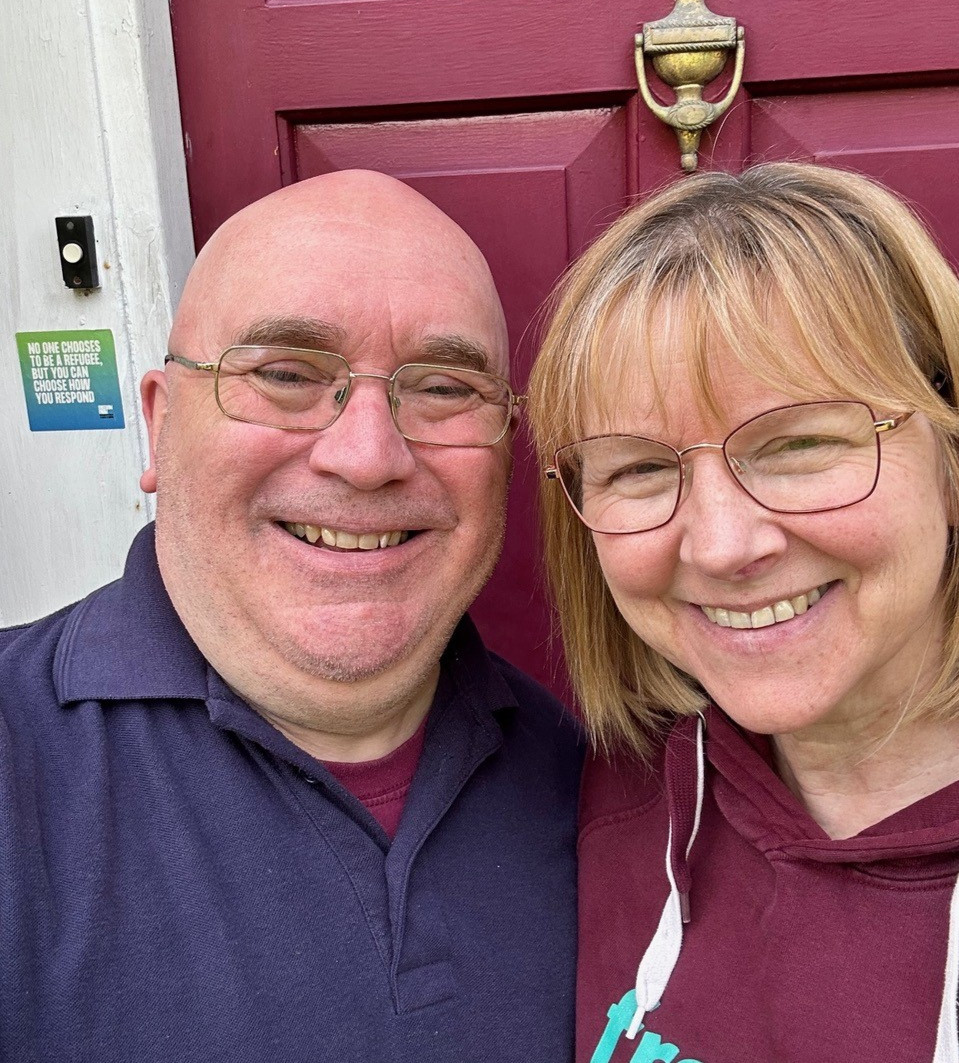A selfie of a man and a woman outside their front door