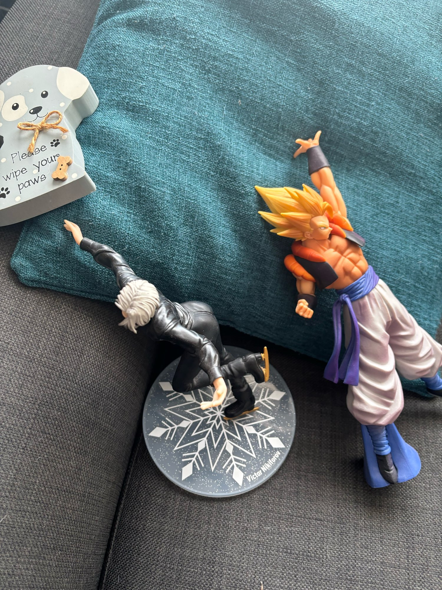 A please wipe your paws dog, a Super Gogeta figure and a Viktor figure on my sofa