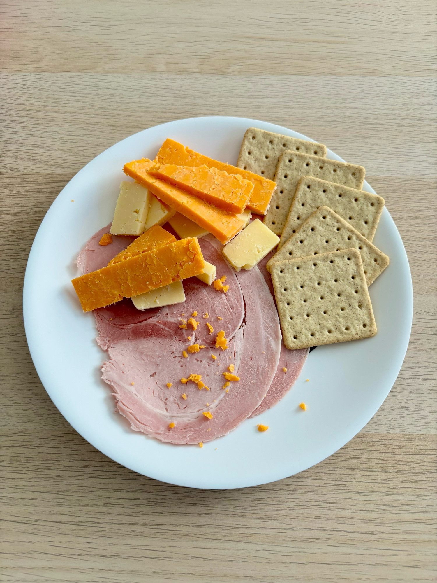 Ham, cheeses and crackers on a plate