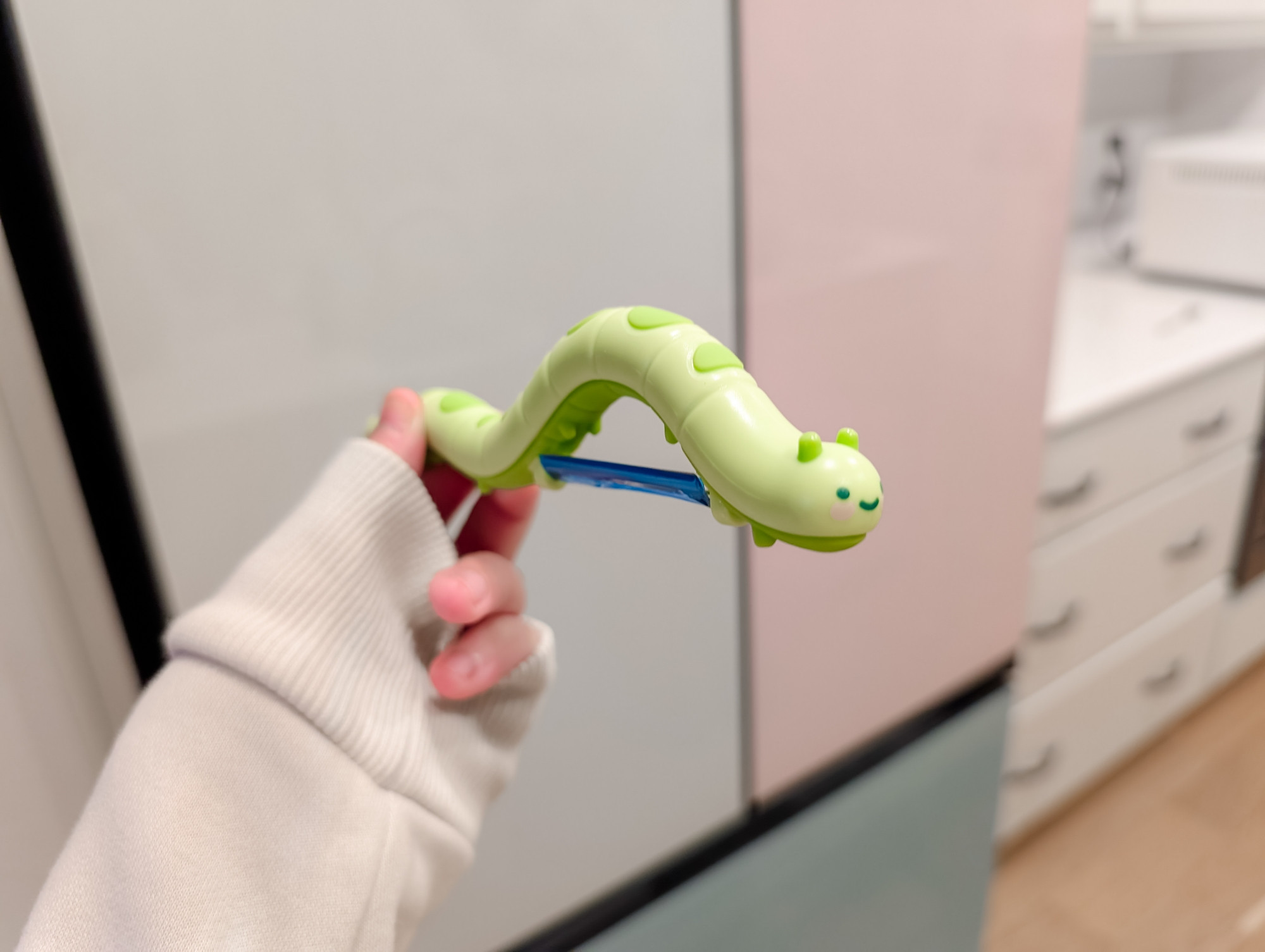 a green caterpillar-shaped vegetable peeler