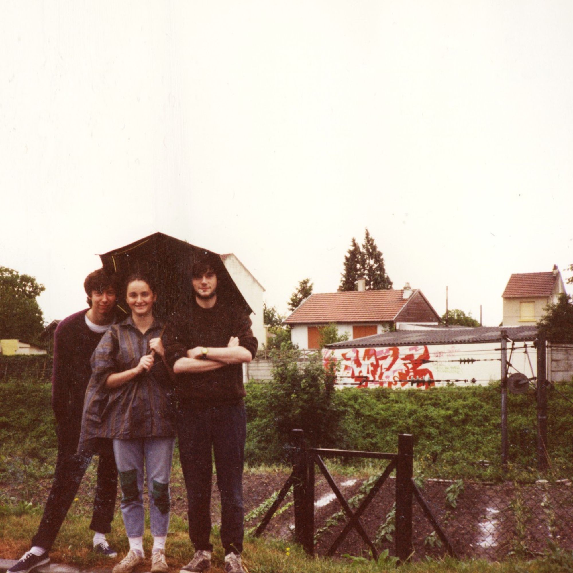 34 Skidoo, Dana 4 et Spray, du Twilight Zone Crew, posant fièrement devant un graffiti inachevé qu'ils ont commis le long d'une ligne de chemin de fer de la banlieue parisienne. Vers 1989.