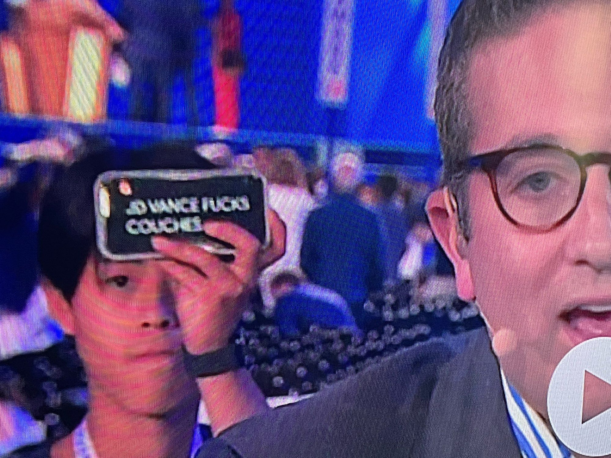 During a MSNBC Broadcast a young man holds up his phone, which reads “JD VANCE FUCKS COUCHES” behind reporter Jake Sherman