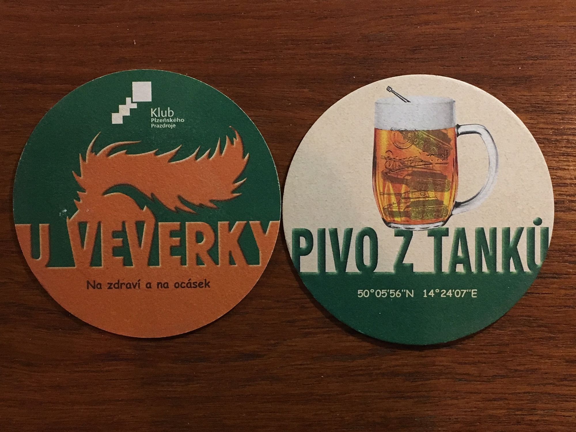 coaster from the Prague (Dejvice quarter) pub U Veverky (at the Squirrel) https://www.uveverky.com/

the front side shows an orange squirrel tail on a green ground
the back side, advertising beer "from the tank," shows a tank--an actual armored vehicle--in a mug of beer