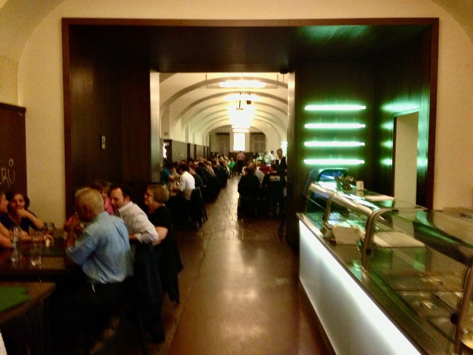 one of the "Lokal" chain of pubs in Prague, which serves beer from the tank

long vaulted hall with white ceiling, long rows of tables down the sides (glass refrigerated cases for food at right)