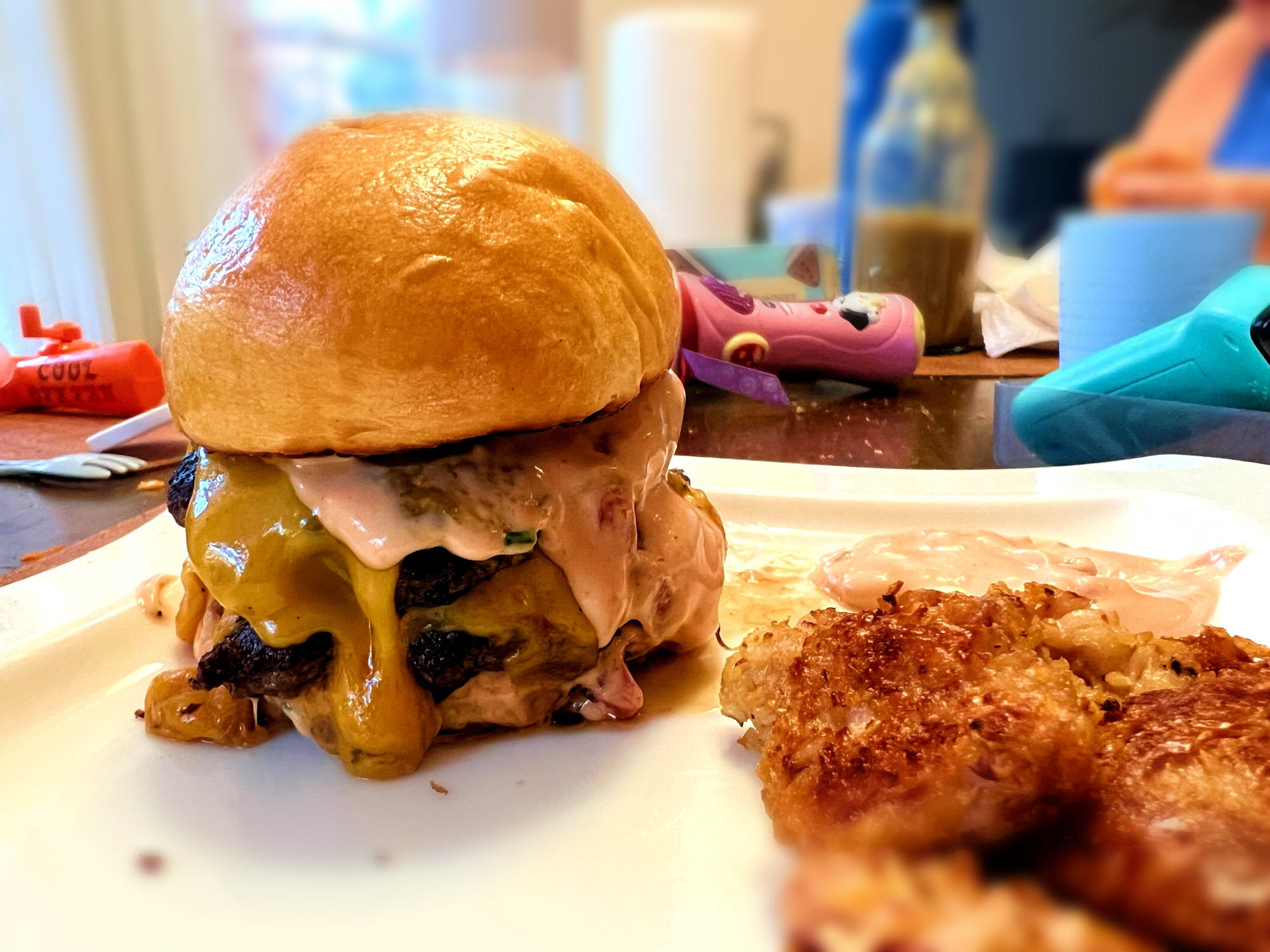 A double cheeseburger w/ cheese and sauce just oozing down like a disgustingly glorious flood. There are a few tot looking things on the right side