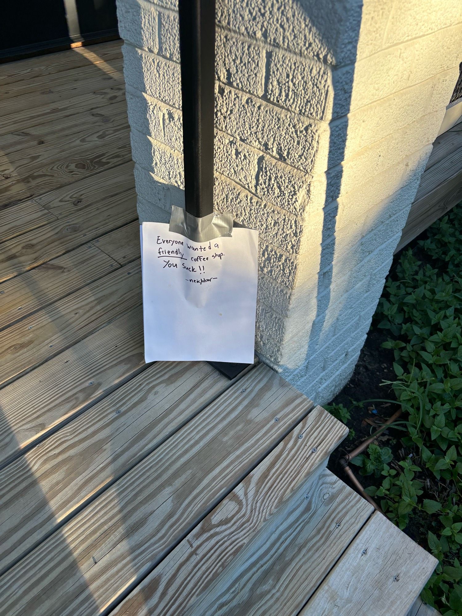 Note taped to stairs reading: 

Everyone wanted  a FRIENDLY coffee shop.  You Suck!!
- Neighbor