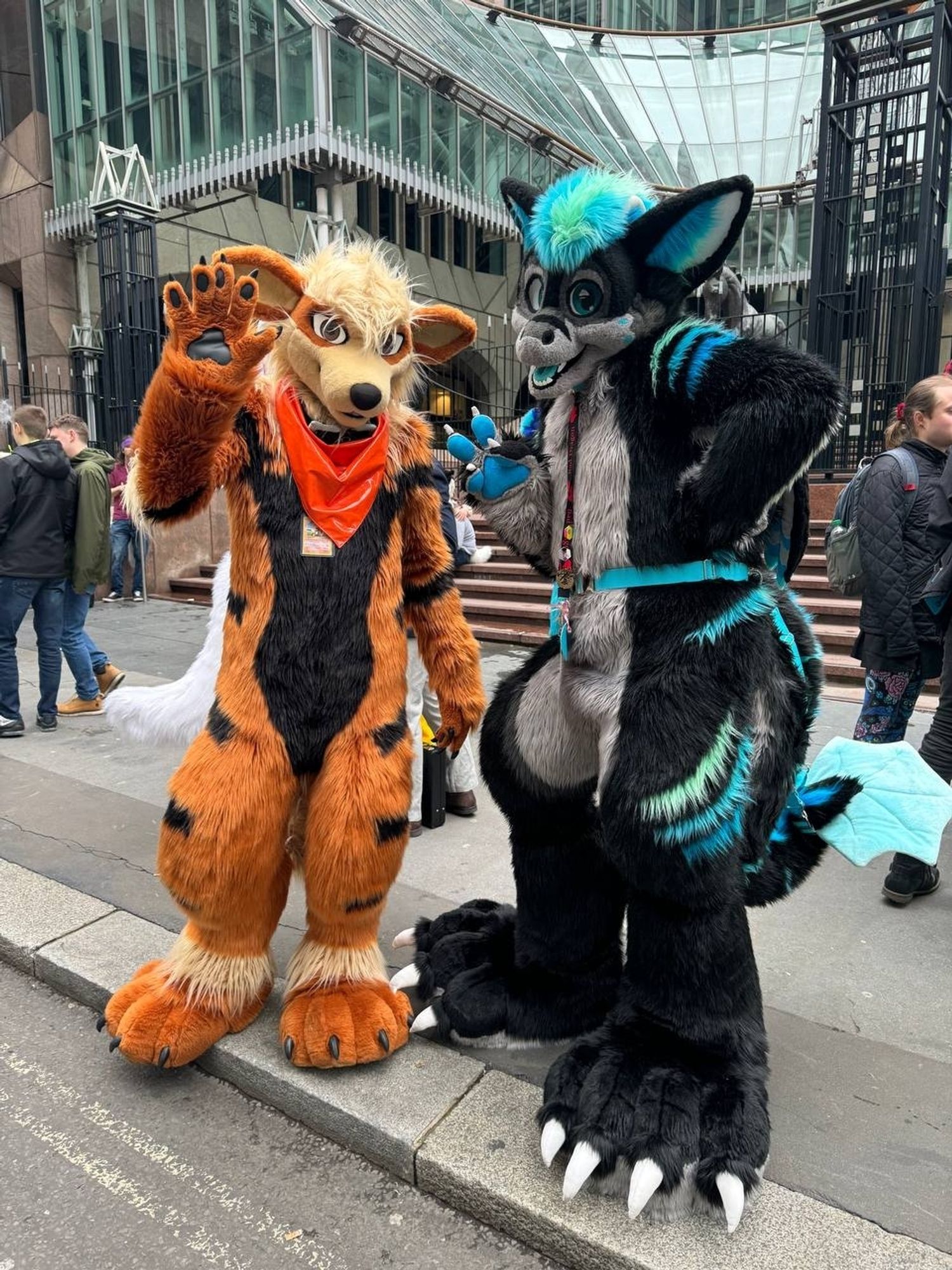 Arcanine fursuiter and a fluffy dragon fursuiter pose for camera