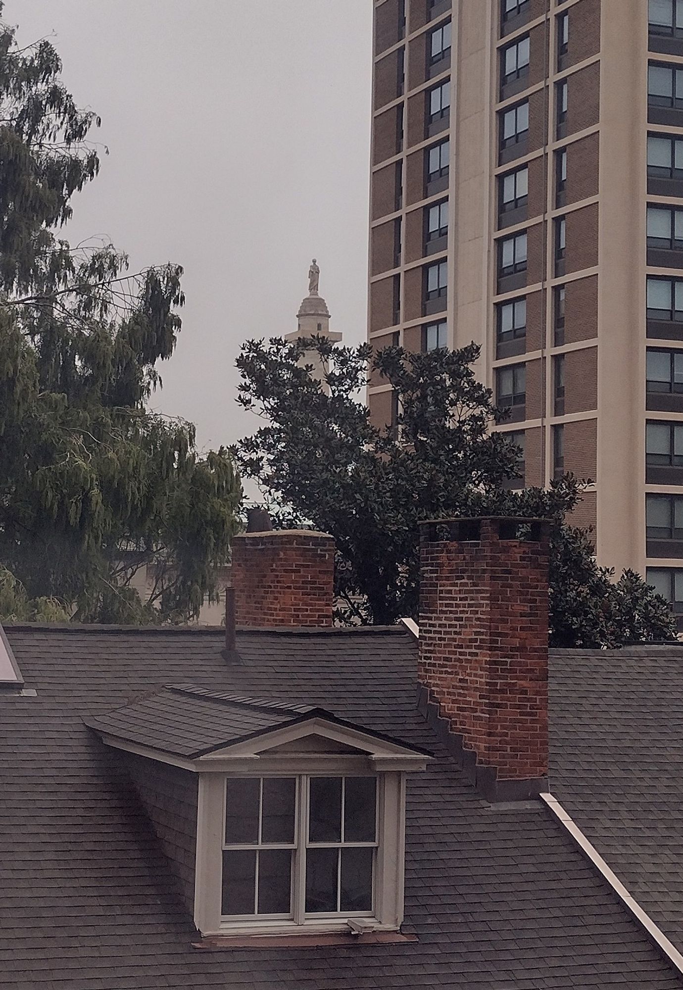 Baltimore's Washington Monument, first one in the nation, same architect as the one in DC, viewed at a distance through a grimy hotel window