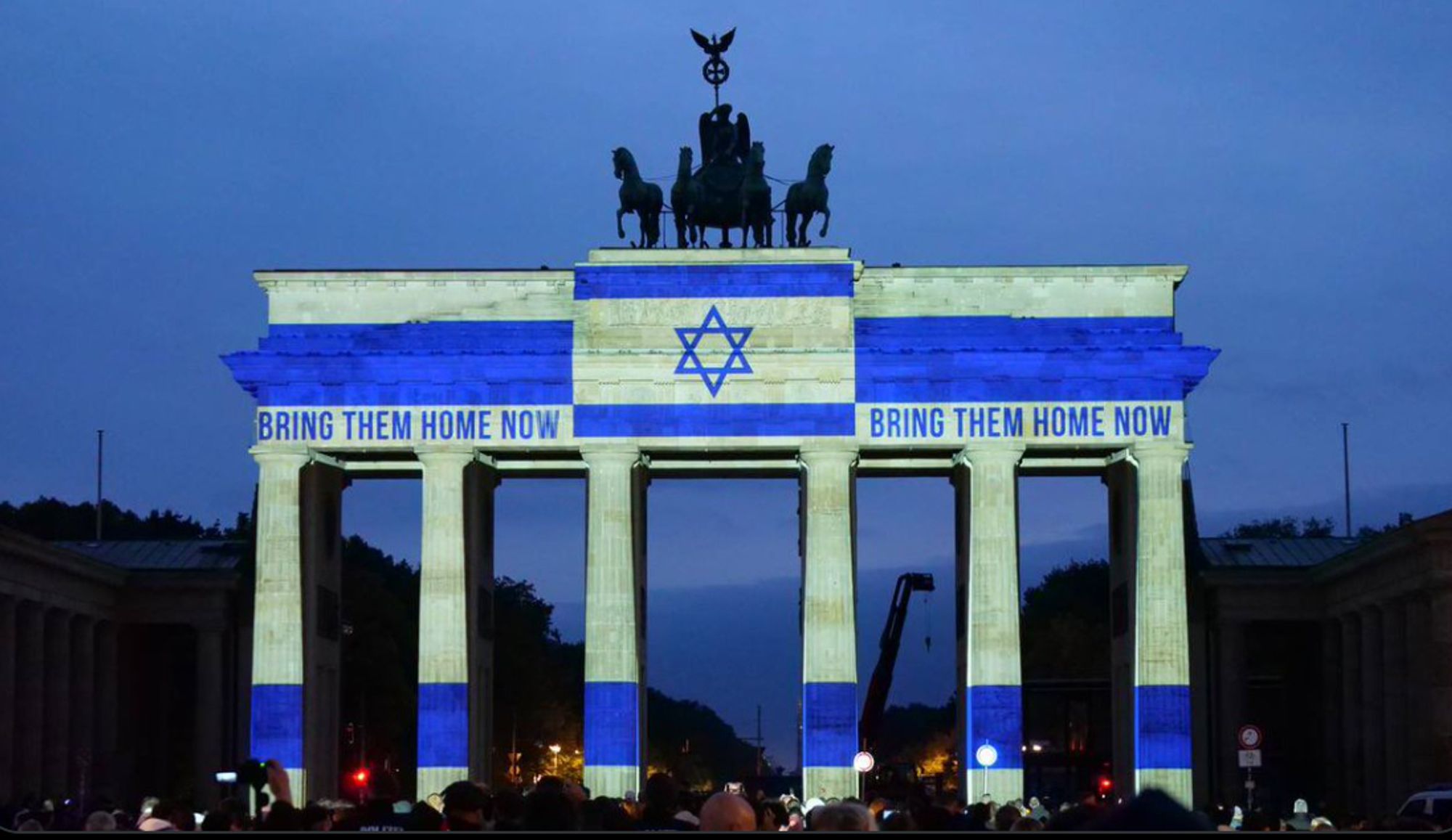 Abends: Brandenburger Tor angestrahlt in blau-weiß (Flagge Israels), oben in der Mitte der Davidstern.