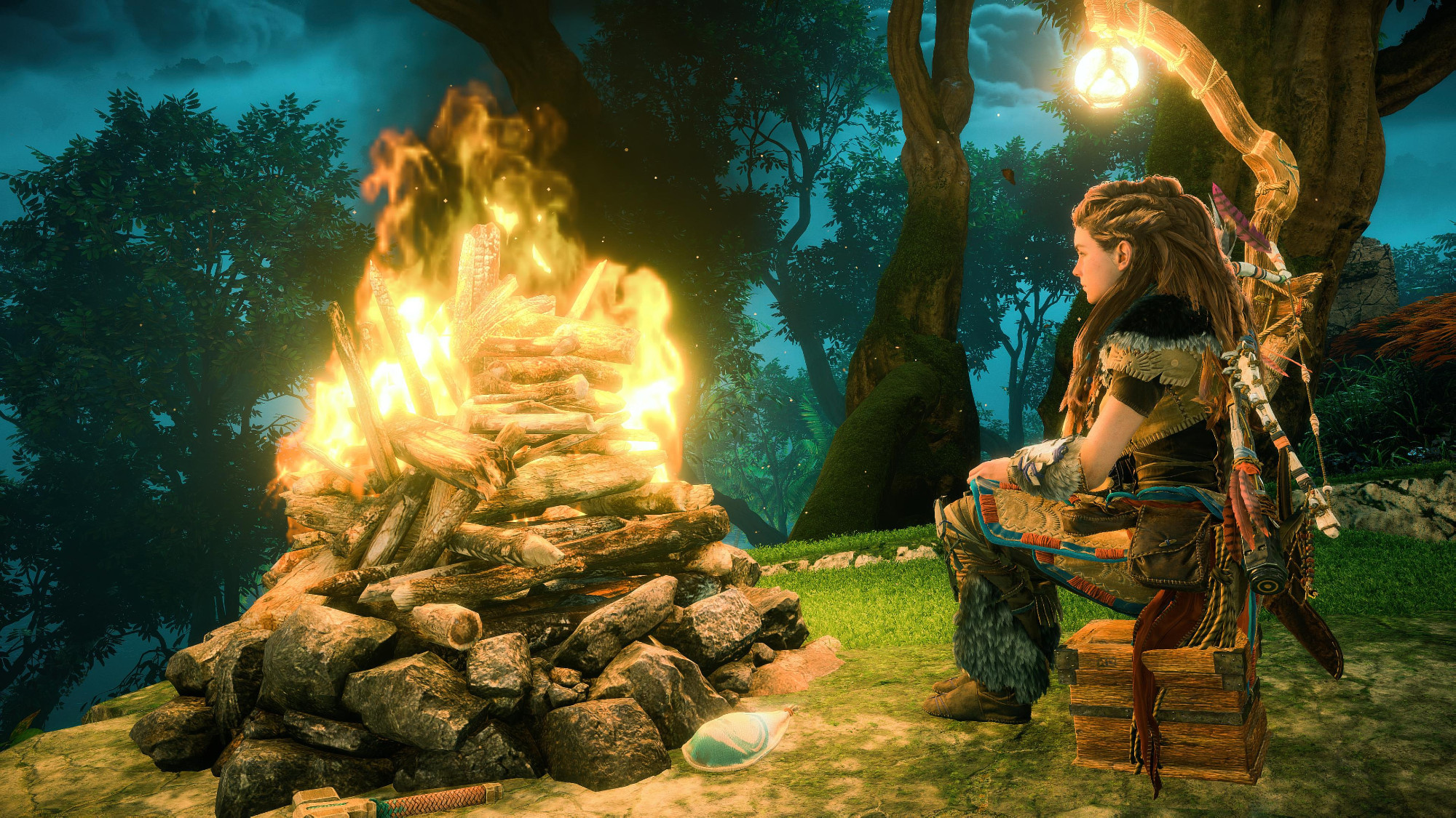 Aloy, collecting her thoughts seated near a campfire.