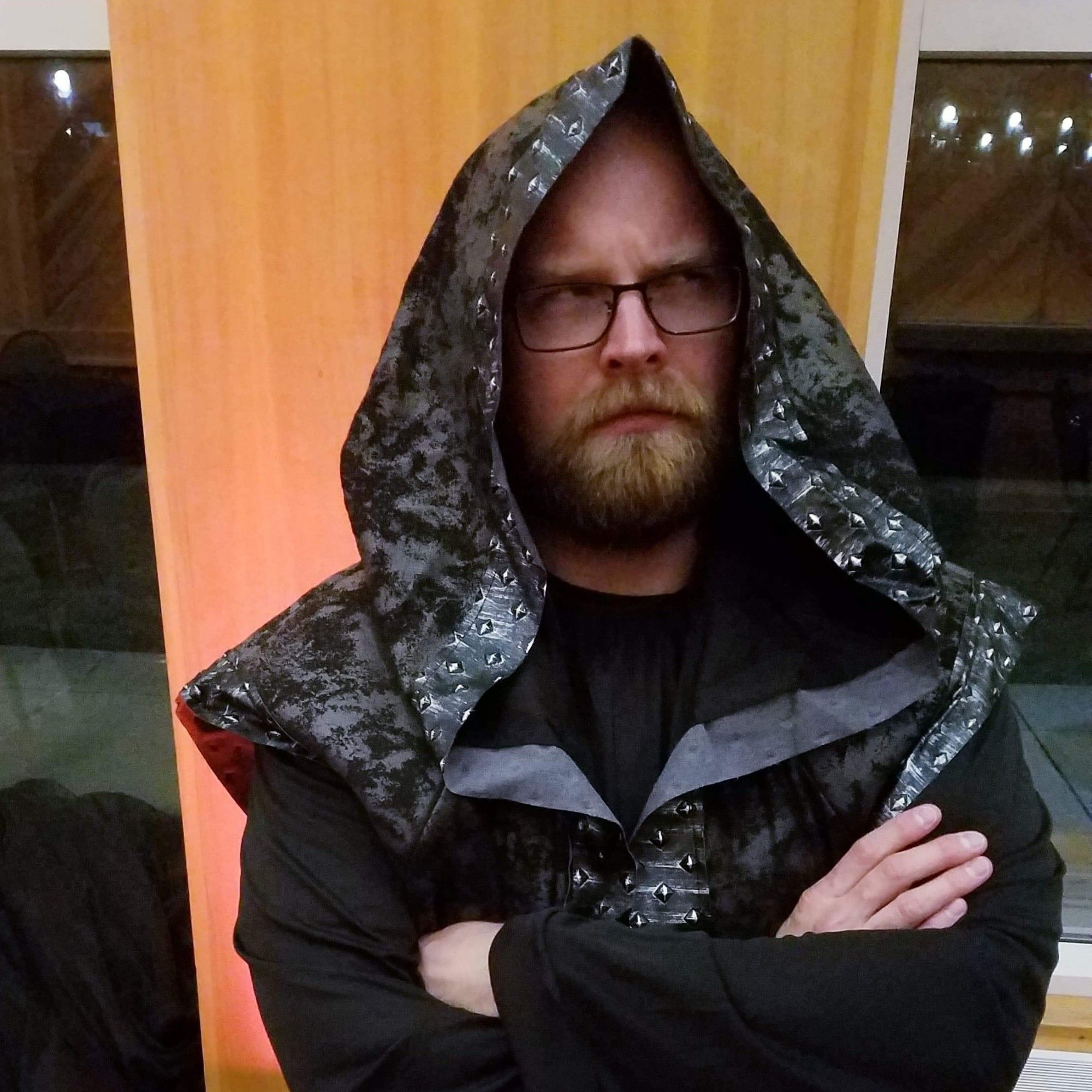 Bearded person in black hooded robes