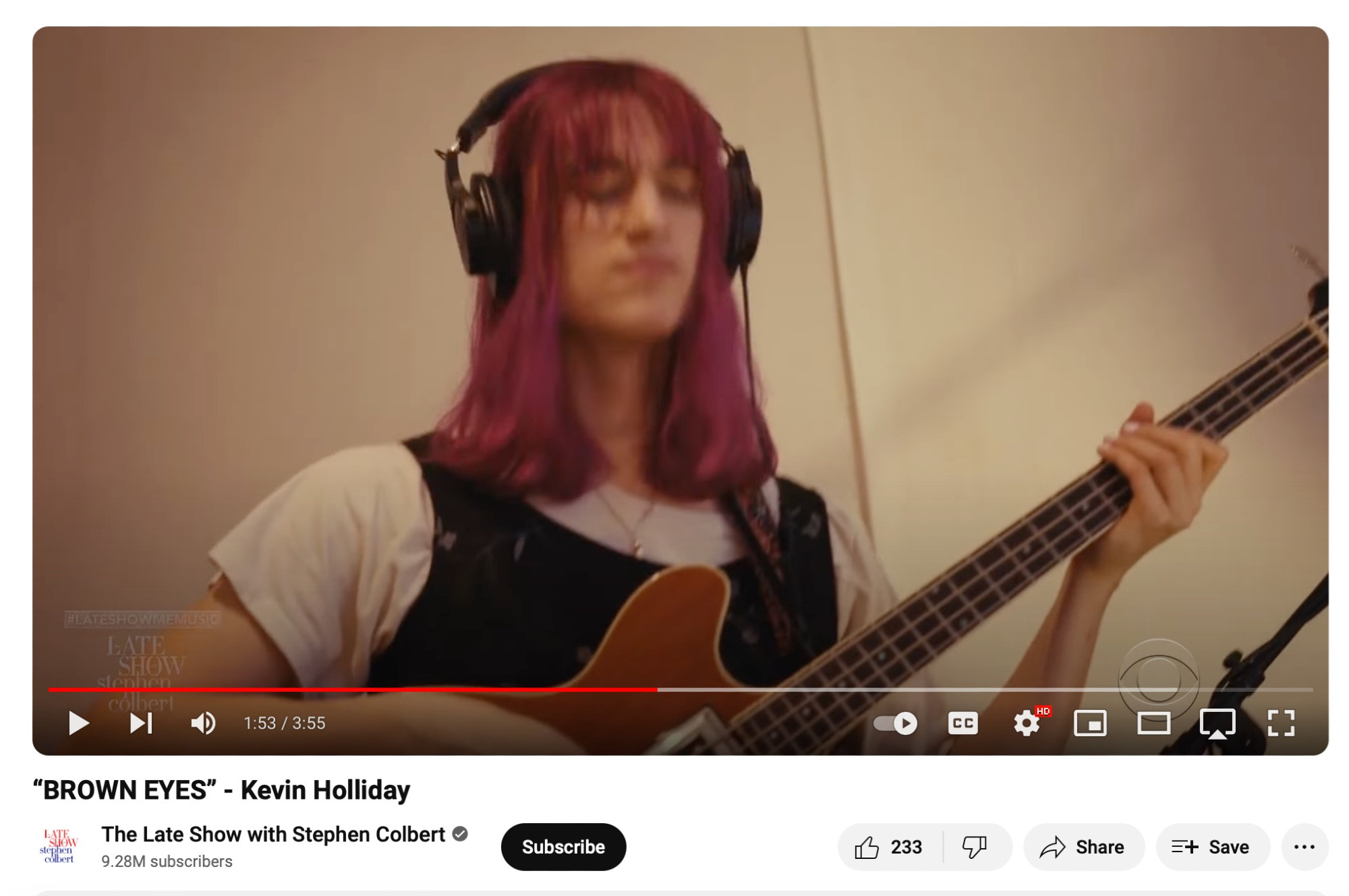 Woman with pink hair plays the bass guitar