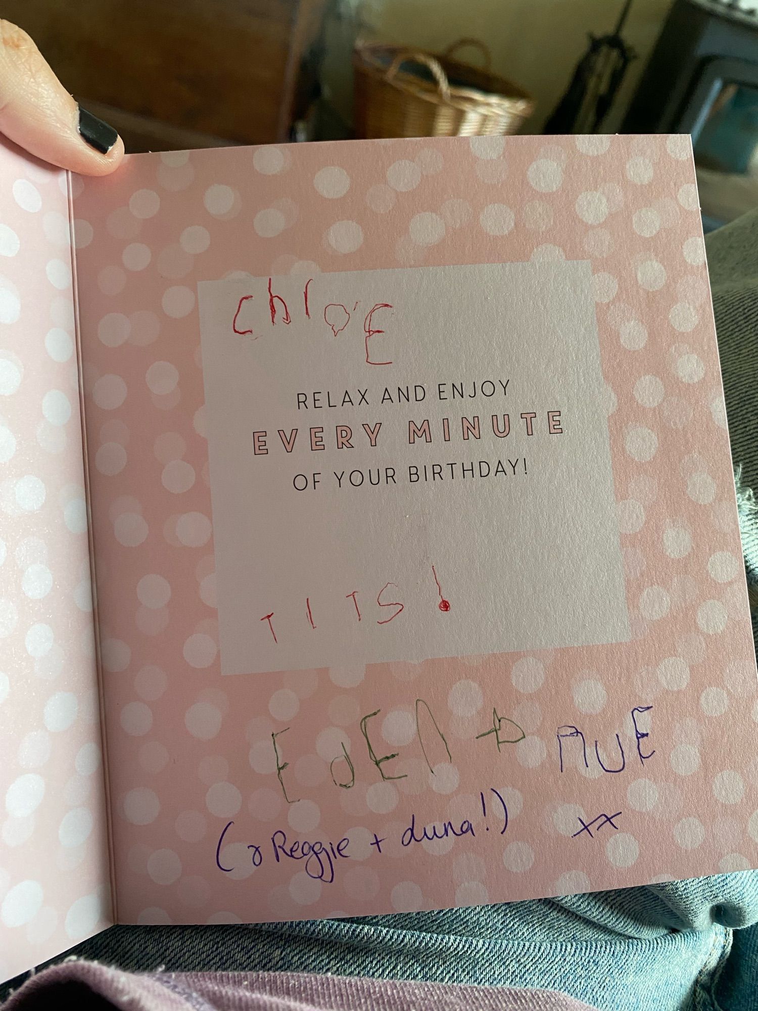 The inside of a salmon pink birthday card. Inside there is very wobbly child’s hand writing, of my and their names, and also TITS! Has been scrawled across it